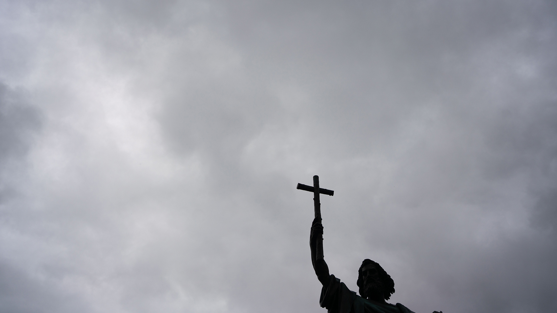 Die Statue des heiligen Bonifatius steht vor einem regenschweren Himmel. | picture alliance/dpa