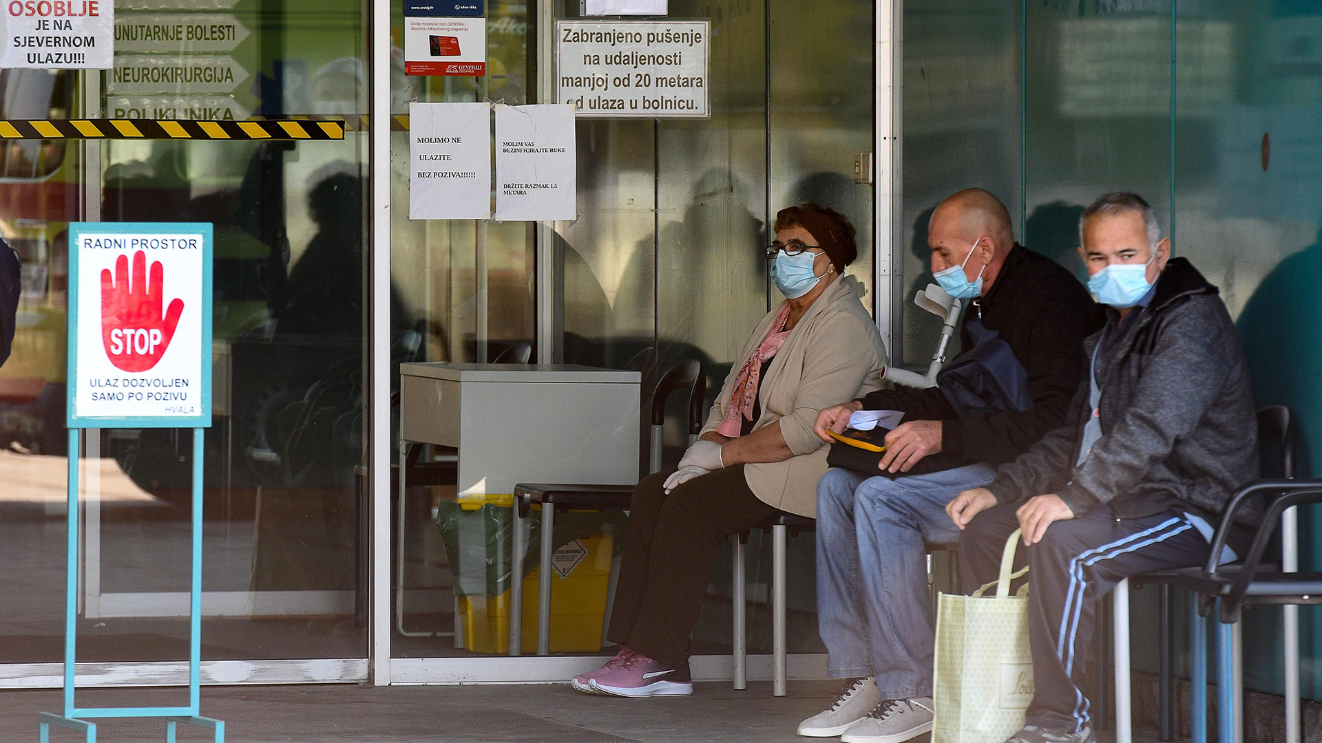Kroatien, Zagreb: Menschen mit Gesichtsmasken warten vor dem Krankenhaus Dubrava. | AFP
