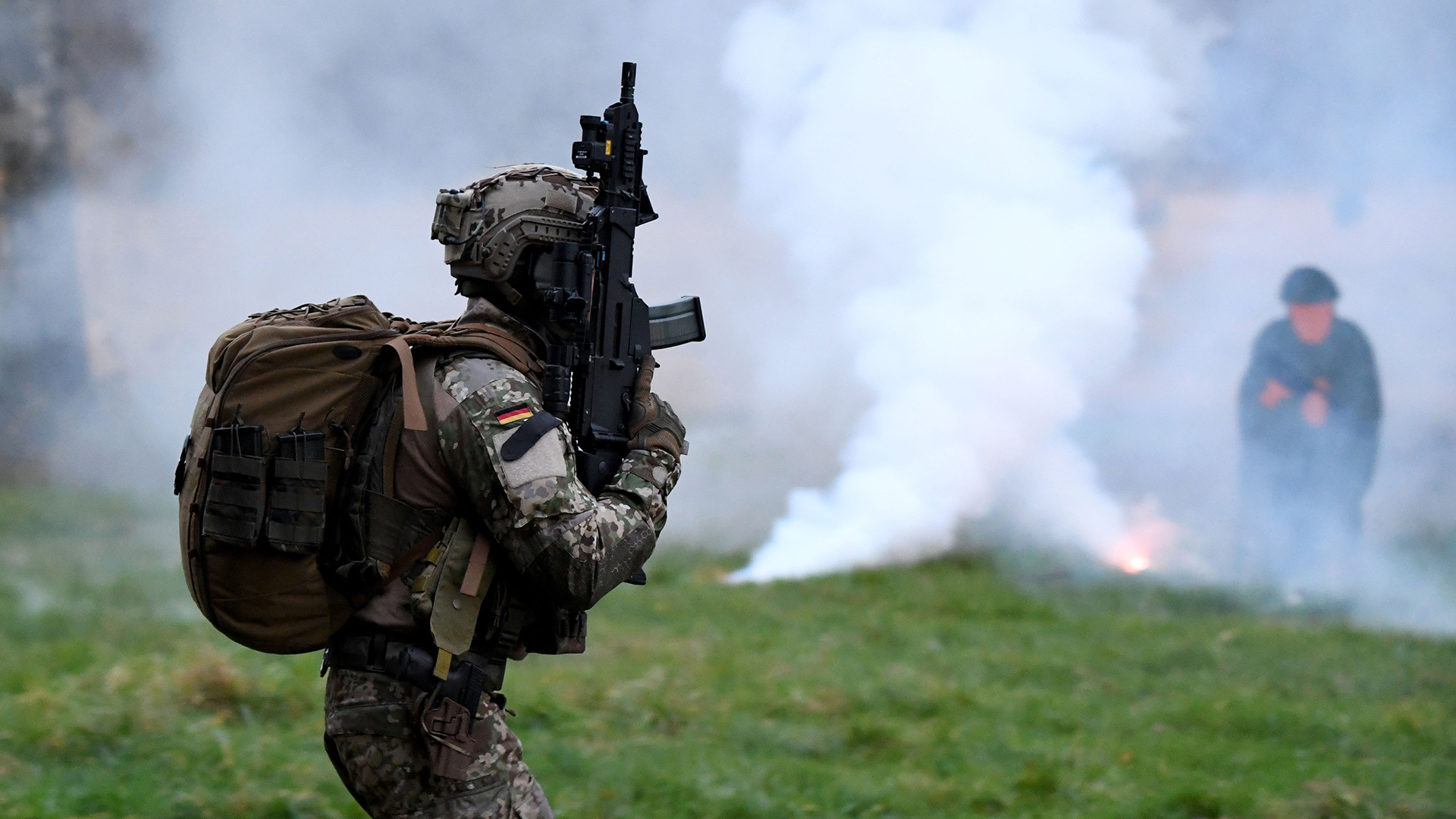 Soldat der KSK im Training mit einem Gewehr - im Hintergrund Rauch | picture alliance/dpa