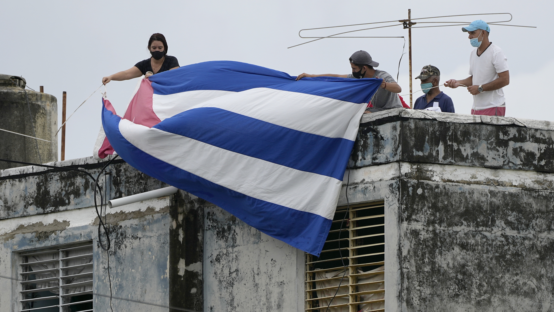  Menschen hängen eine kubanische Flagge über die Fenster des Hauses von Dramatiker Aguilera, um ihn daran zu hindern mit der Außenwelt zu kommunizieren. | dpa