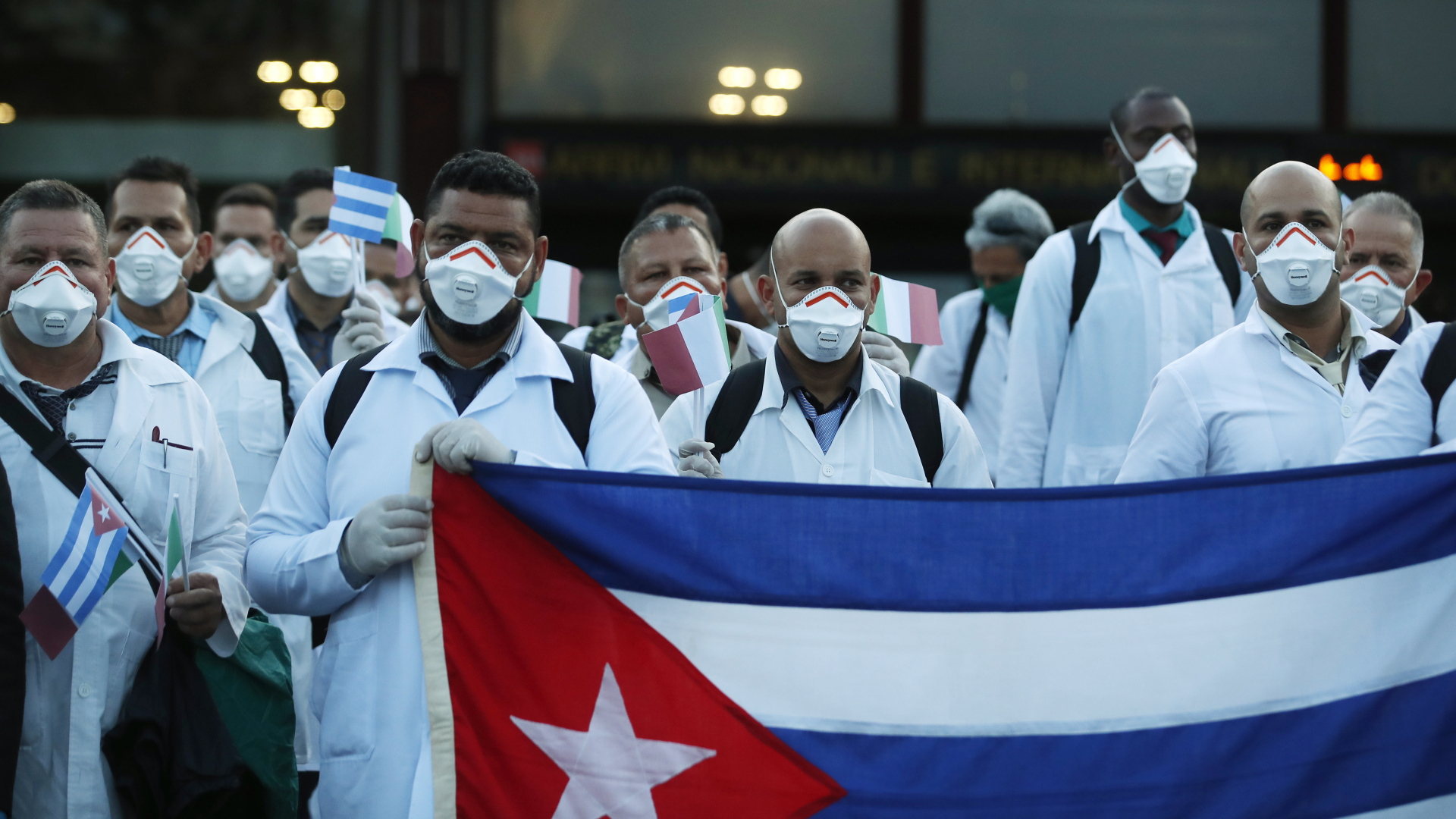 Kubanische Ärzte mit Flagge bei der Ankunft am italienischen Flughafen Malpensa | Bildquelle: dpa