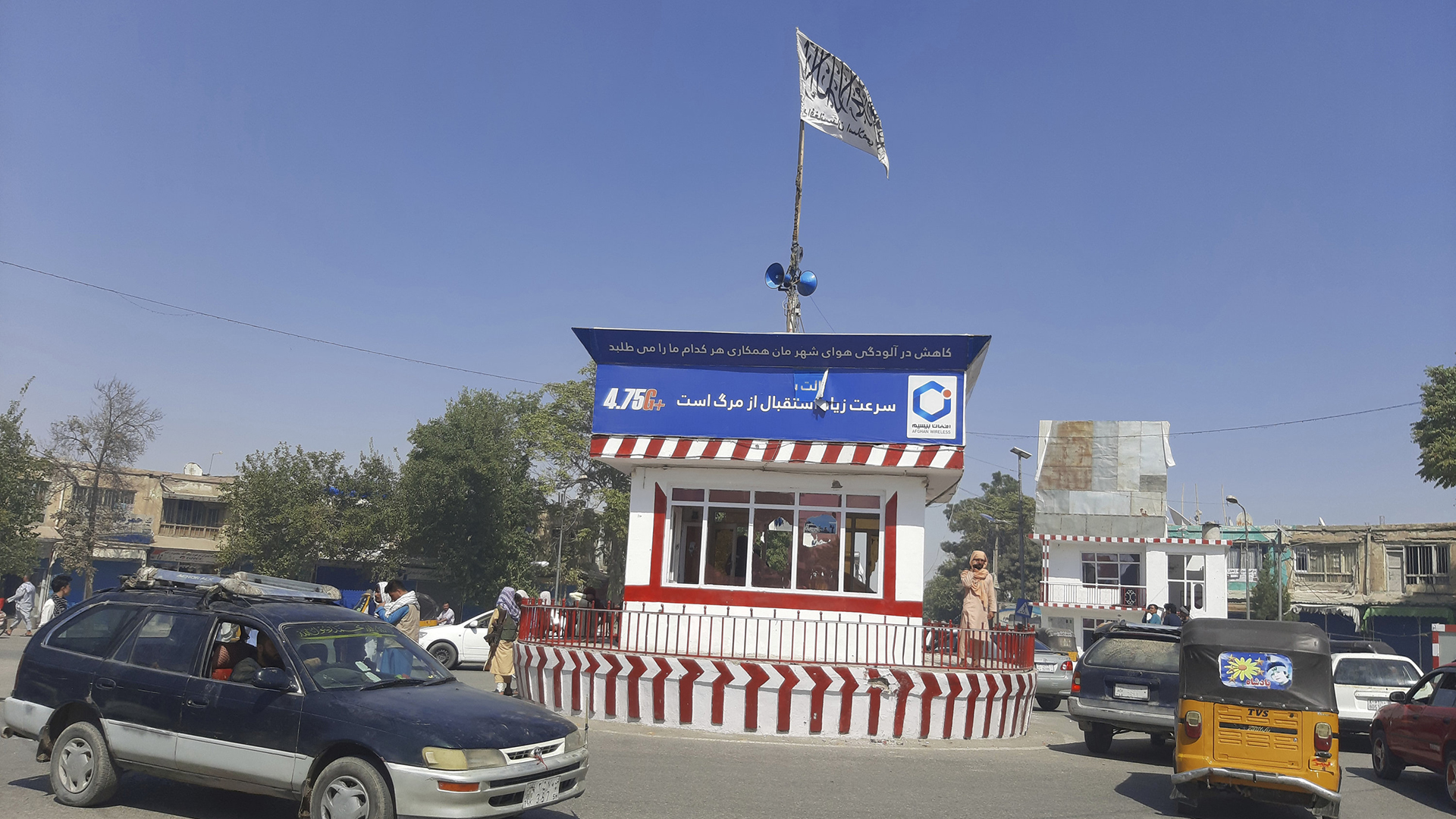 Autos fahren um ein Gebäude mit Taliban-Flagge in Kundus. | AP