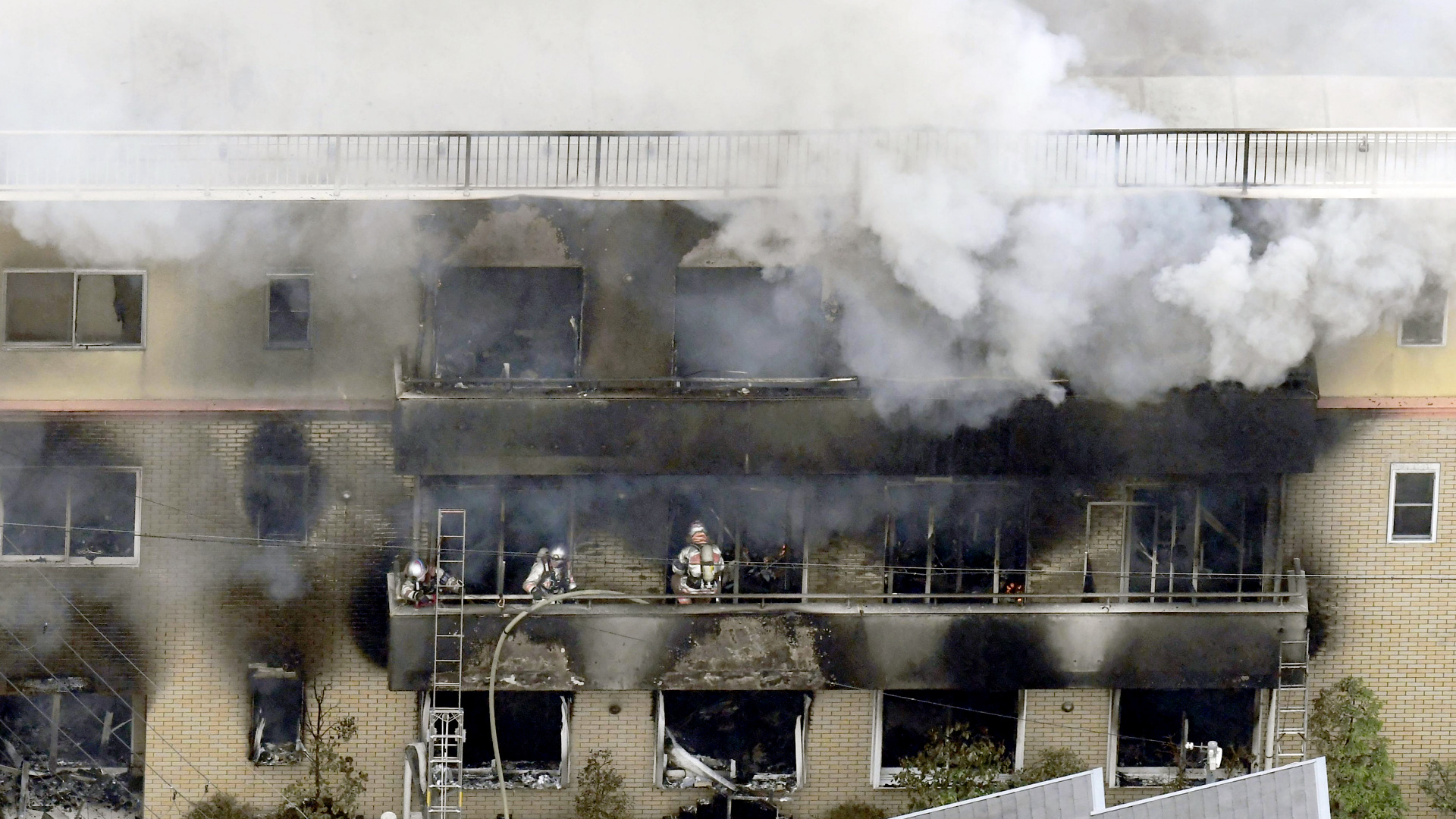 Feuerwehrkräfte stehen im japanischen Kyoto in einem brennenden, mehrstöckigen Animationsstudio. | AP