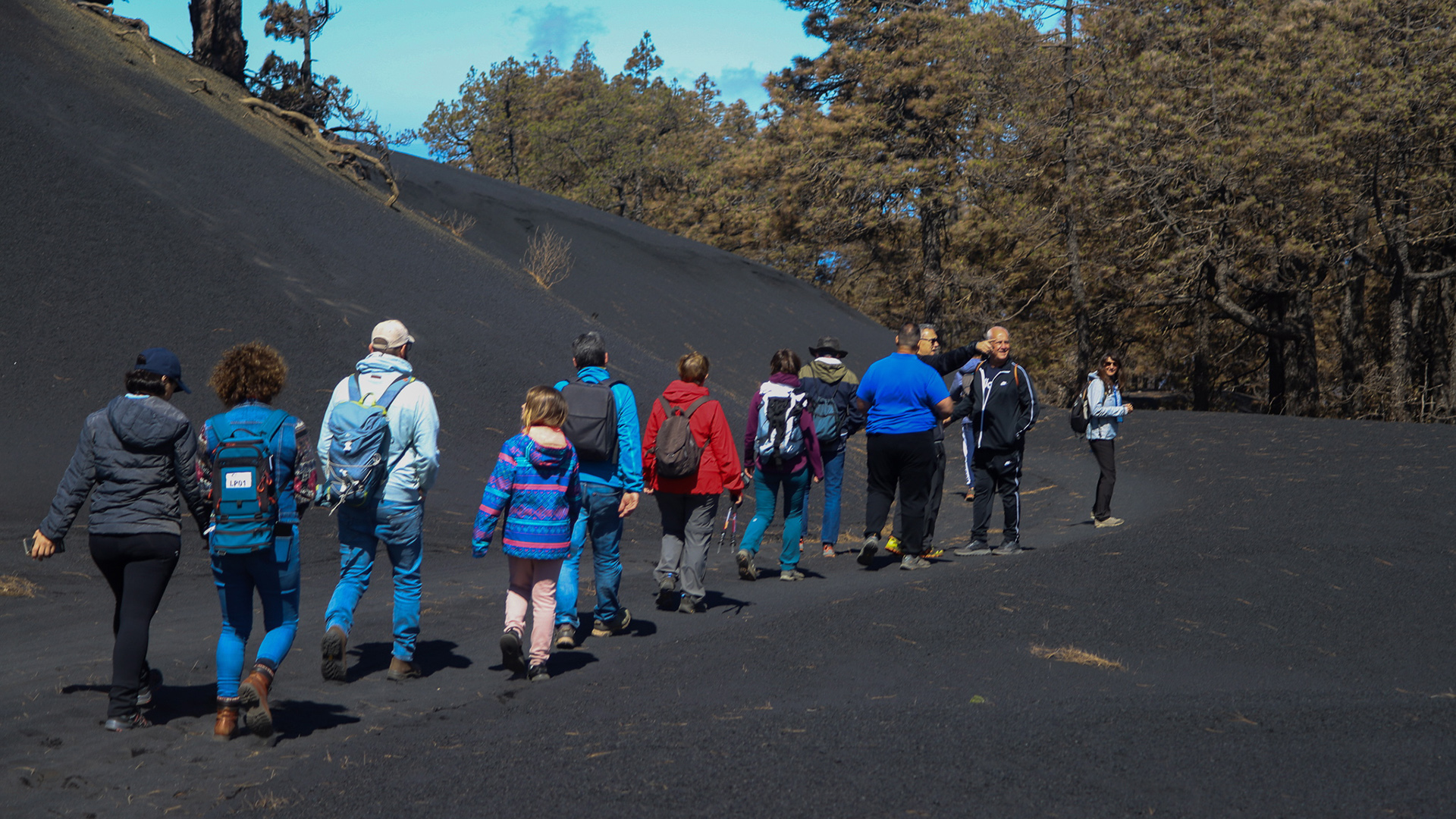 Touristen nehmen an einer geführten Tour durch die Lavaasche des Vulkanausbruchs auf La Palma teil. | EPA