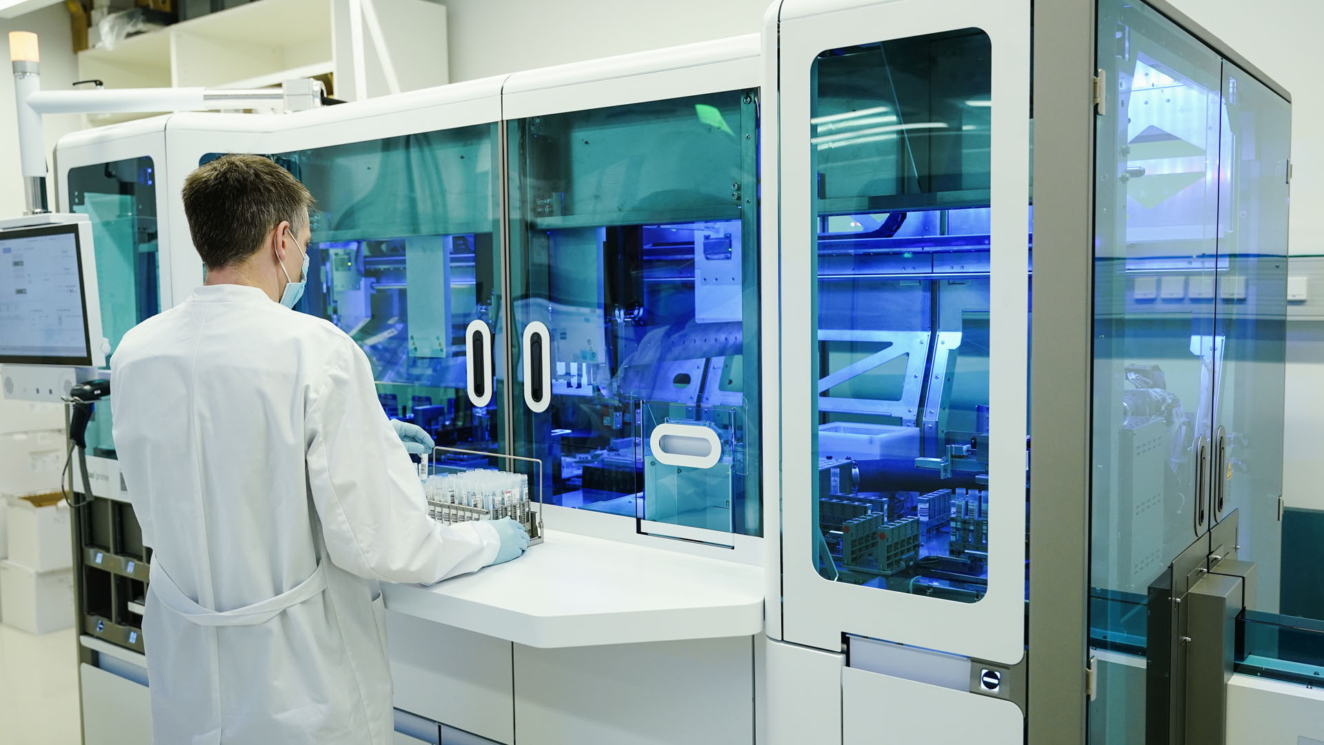 Ein Mitarbeiter hält in einem Coronatest-Labor PCR-Teströhrchen in den Händen.  | picture alliance/dpa