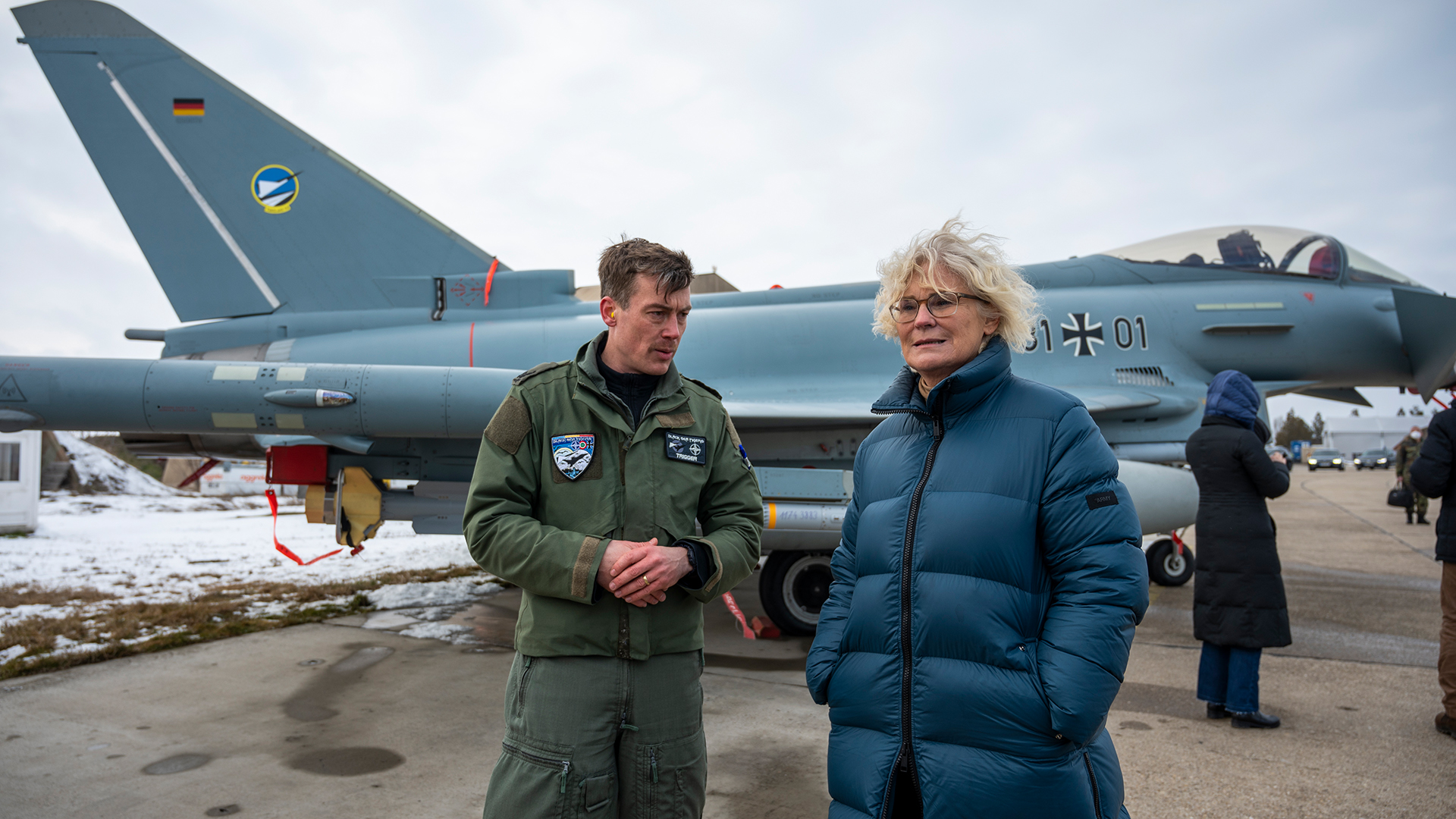 Christine Lambrecht spricht vor einem Eurofighter mit einem Piloten. | dpa