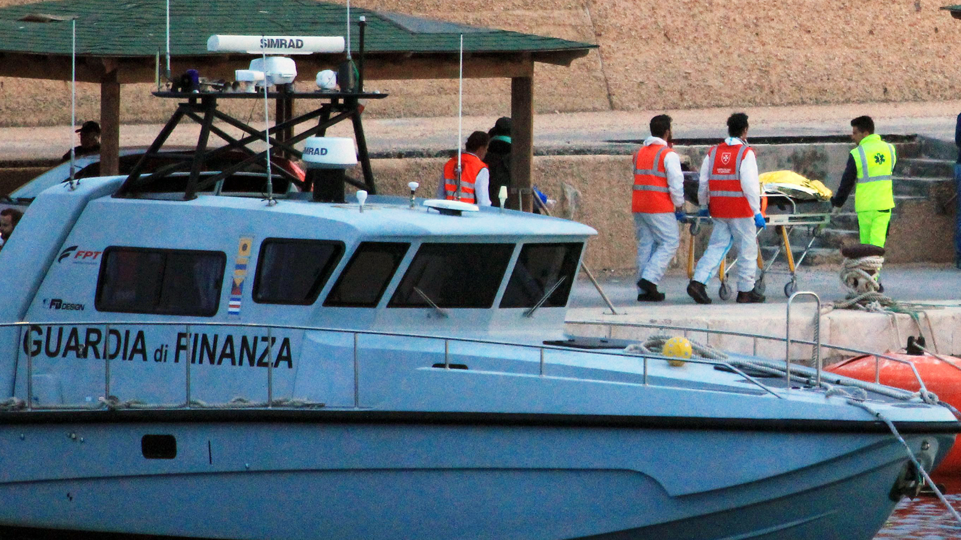 Eine Person wird von Sanitätern vom Boot der italienischen Finanzbehörde gebracht | Giuseppe Milana/EPA-EFE/REX