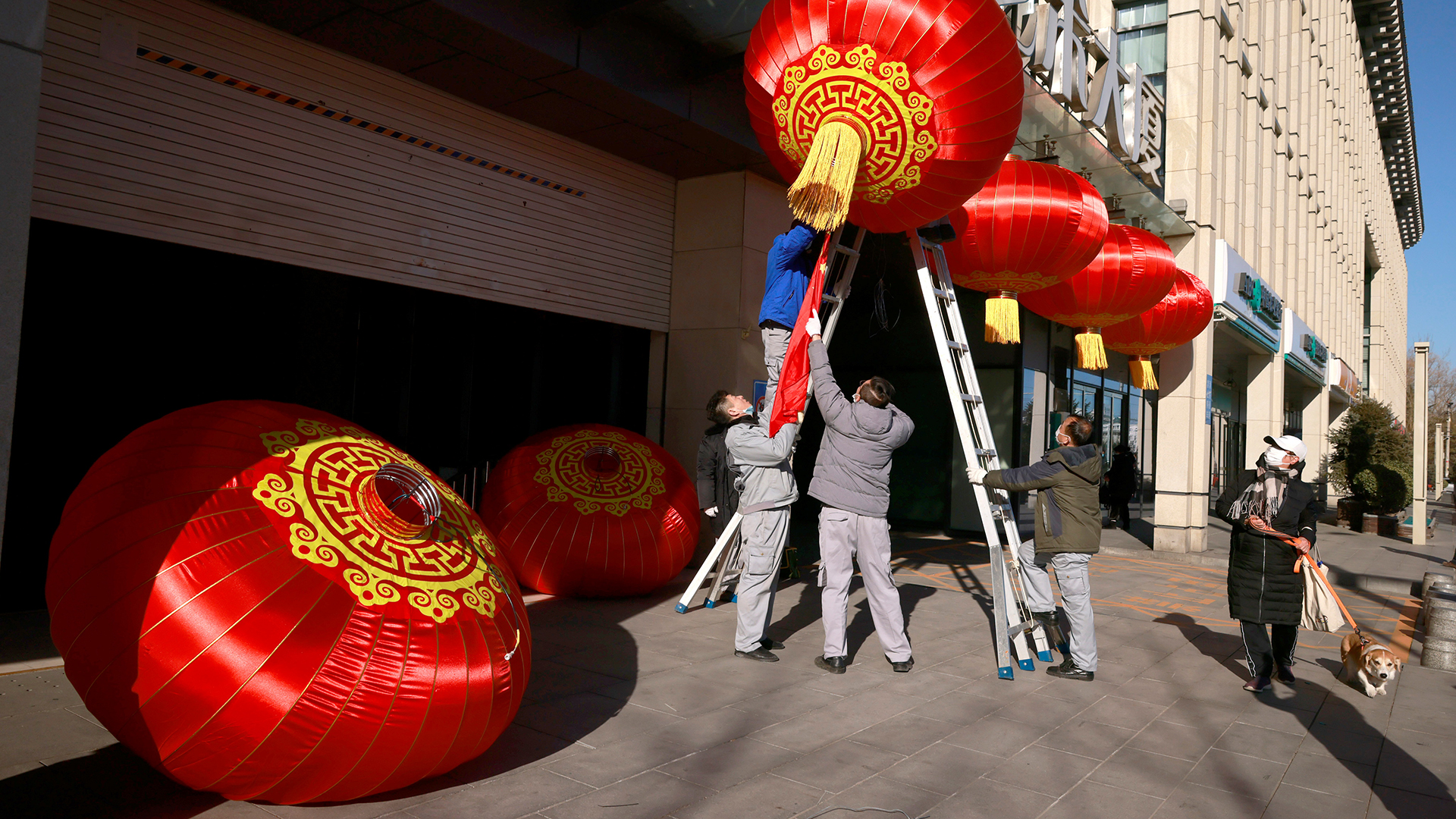Männer hängen in Peking anlässlich des Neujahrsfestes rote Laternen auf. | REUTERS