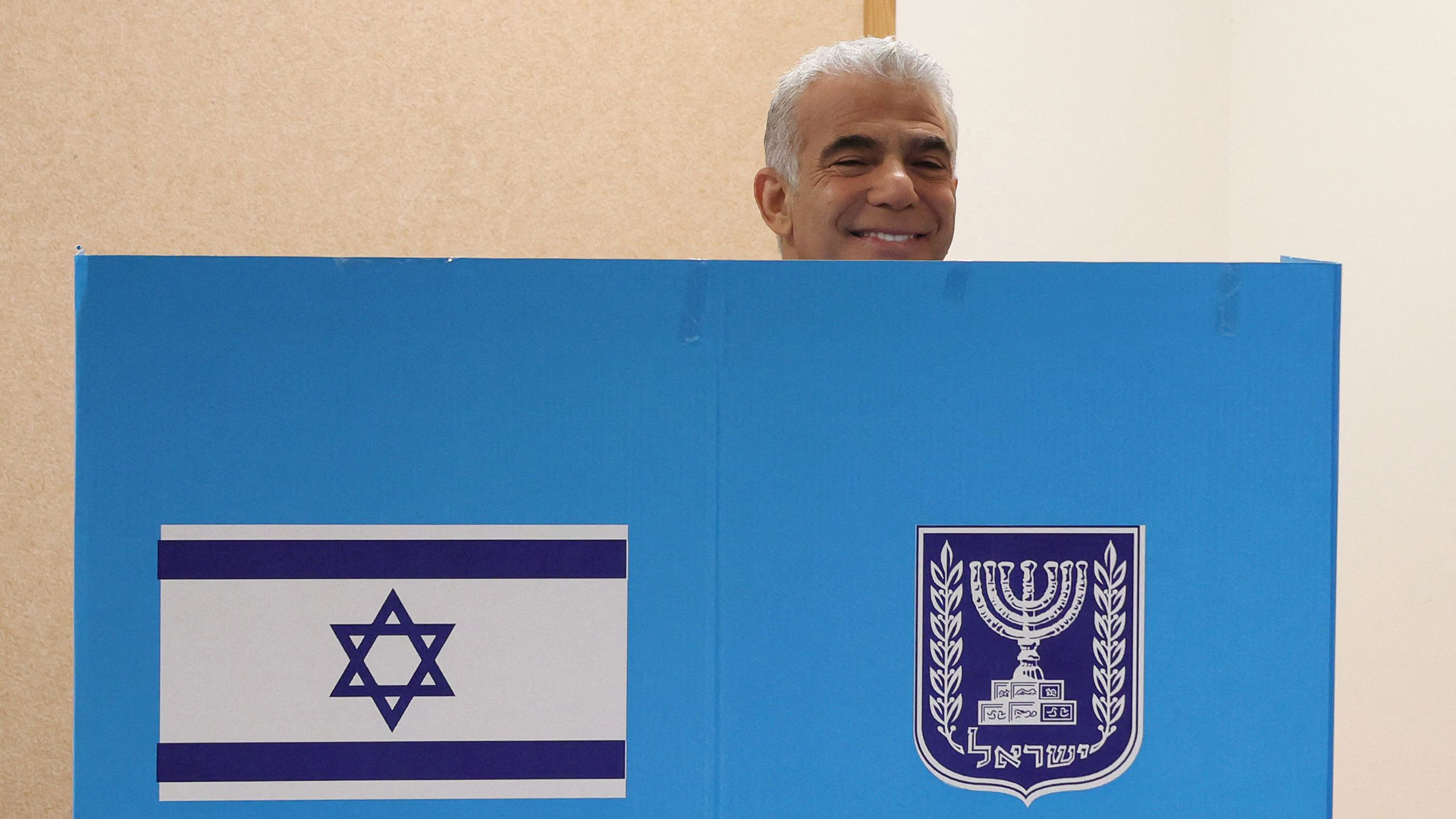 Lapid hinter einem blauen Sichtschutz währen der Wahl in Israel | AFP