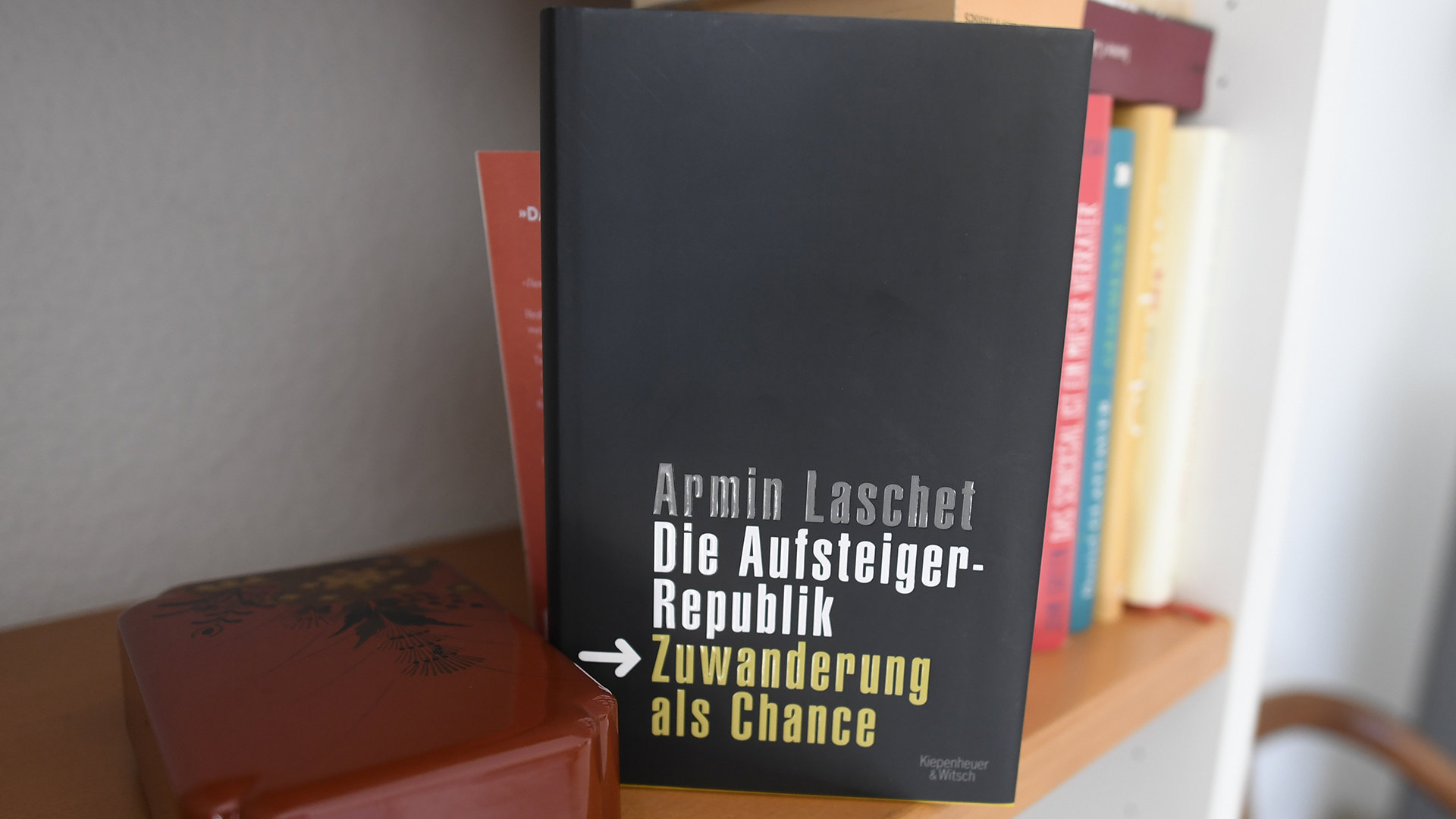Das Buch von Armin Laschet "Die Aufsteiger Republik-Zuwanderung eine Chance" steht in einem Regal. | dpa