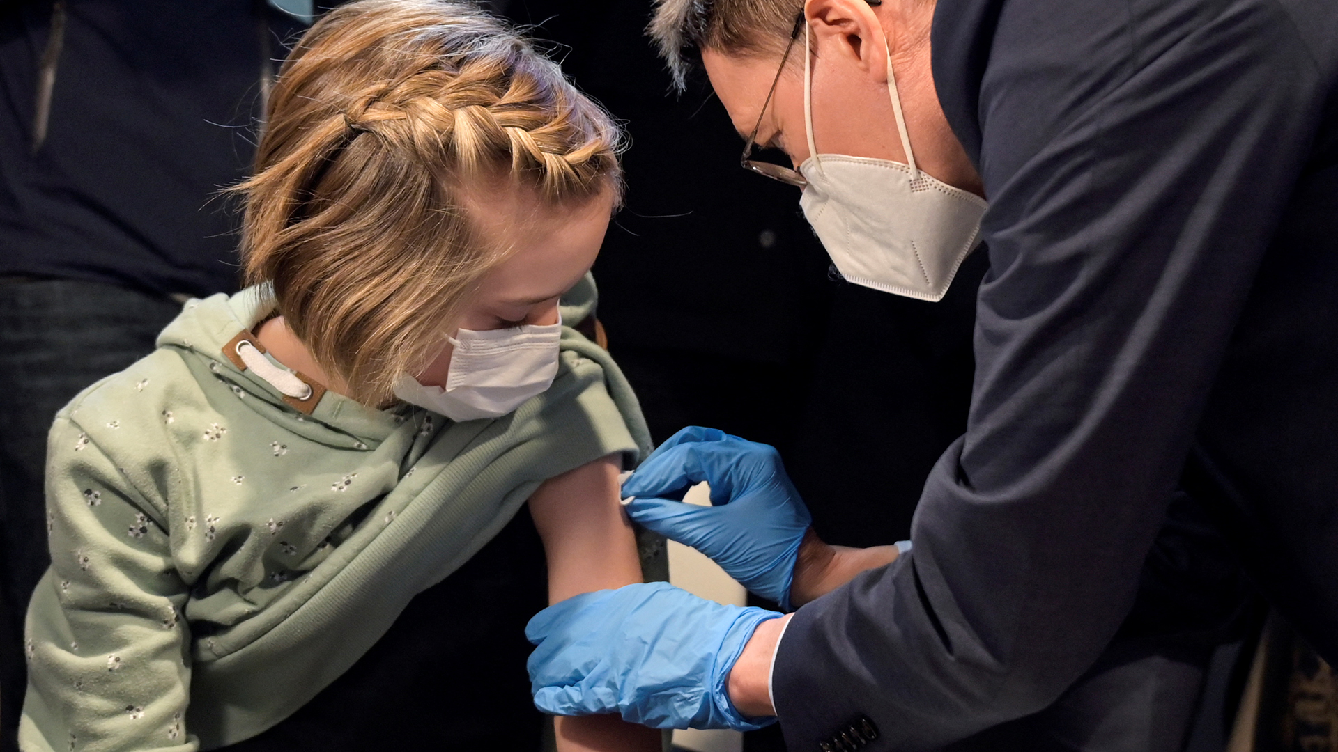 Gesundheitsminister Karl Lauterbach impft ein Mädchen in einem Impfzentrum in Hannover. | REUTERS