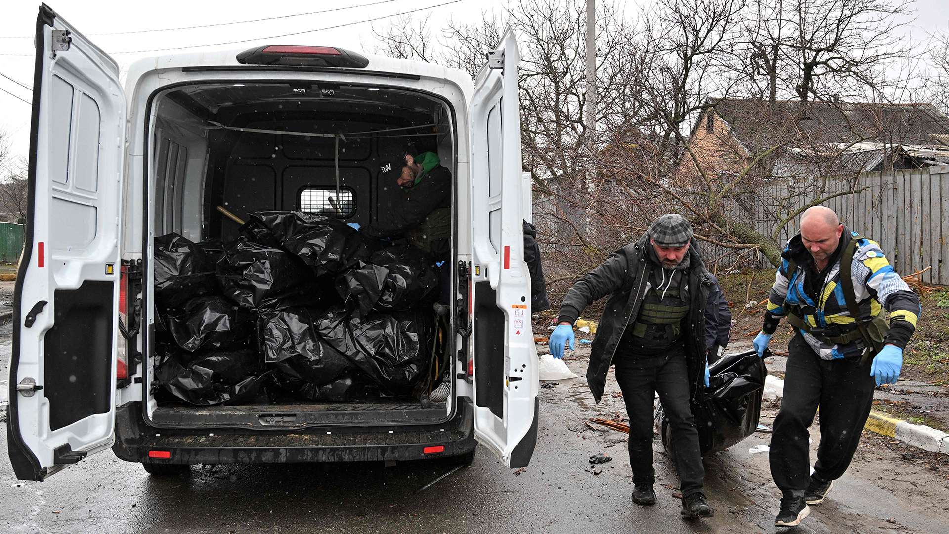 Männer tragen in Butscha die Leiche eines Zivilisten in einen Transporter. | AFP