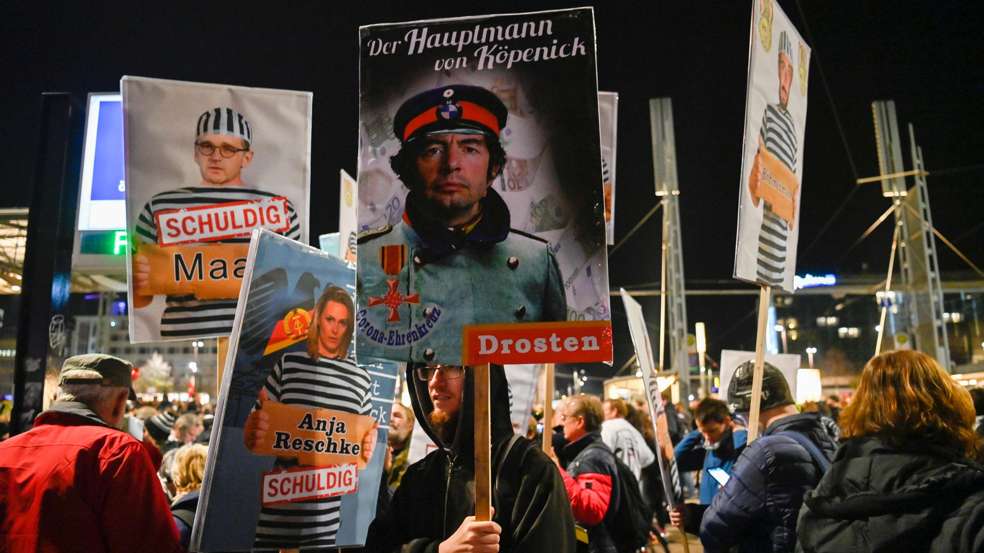 Demonstranten der "Querdenken"-Bewegung halten Schilder in die Höhe.