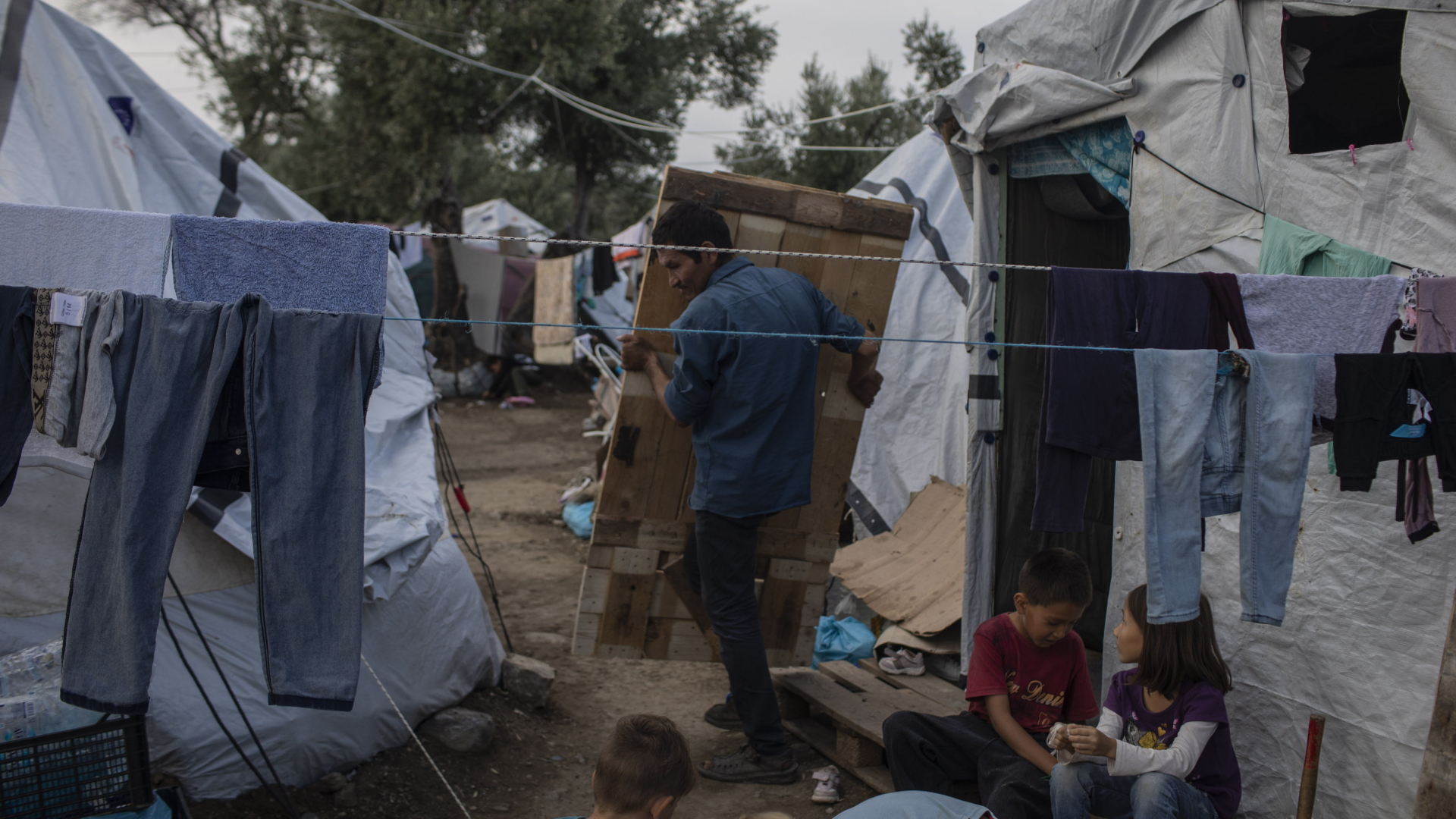 Ein Mann trägt eine Tür zu einem Zelt im Flüchtlingslager Moria auf Lesbos. | AP