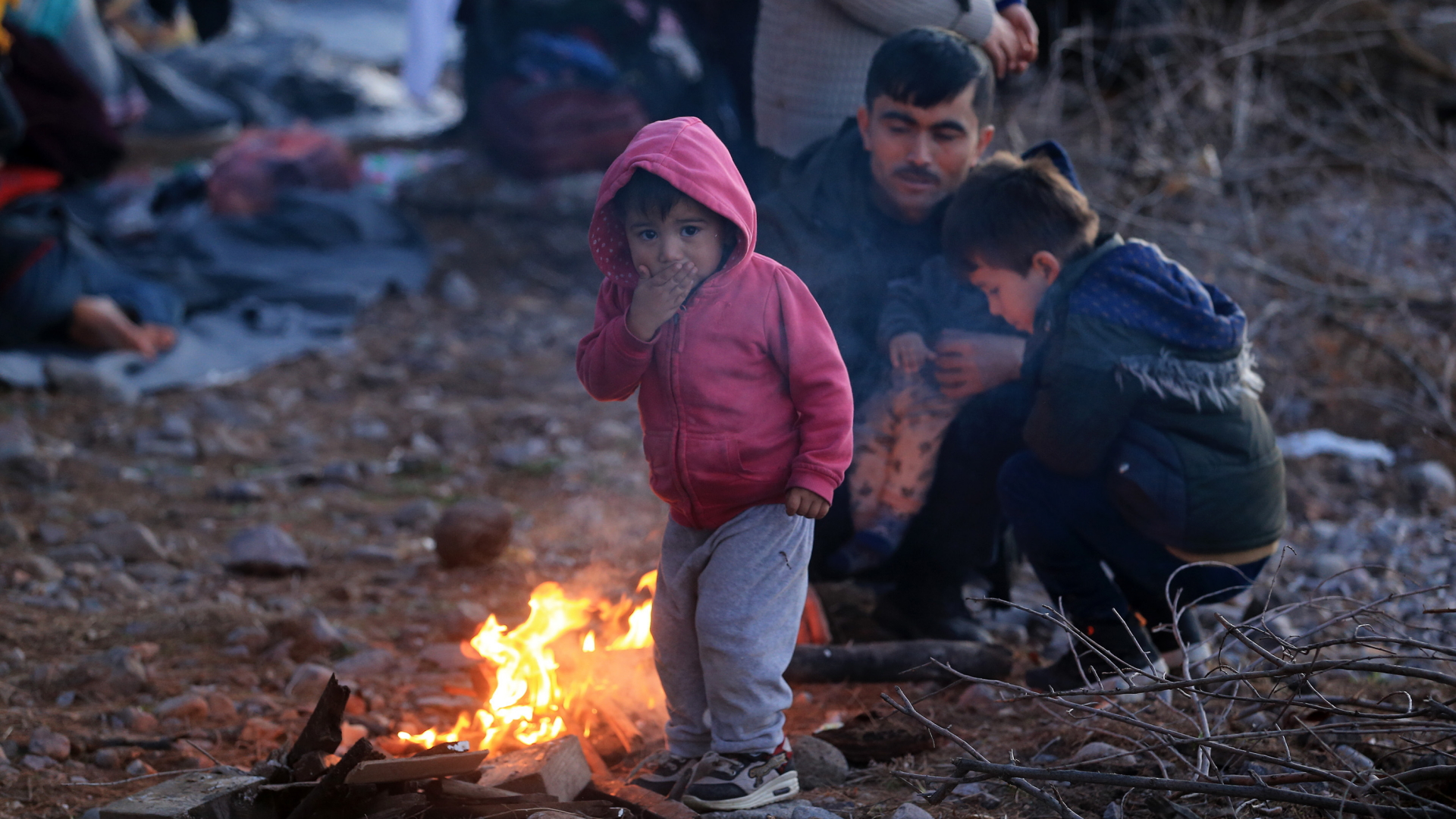 Flüchtlinge auf der griechischen Insel Lesbos wärmen sich an einem Feuer. | dpa