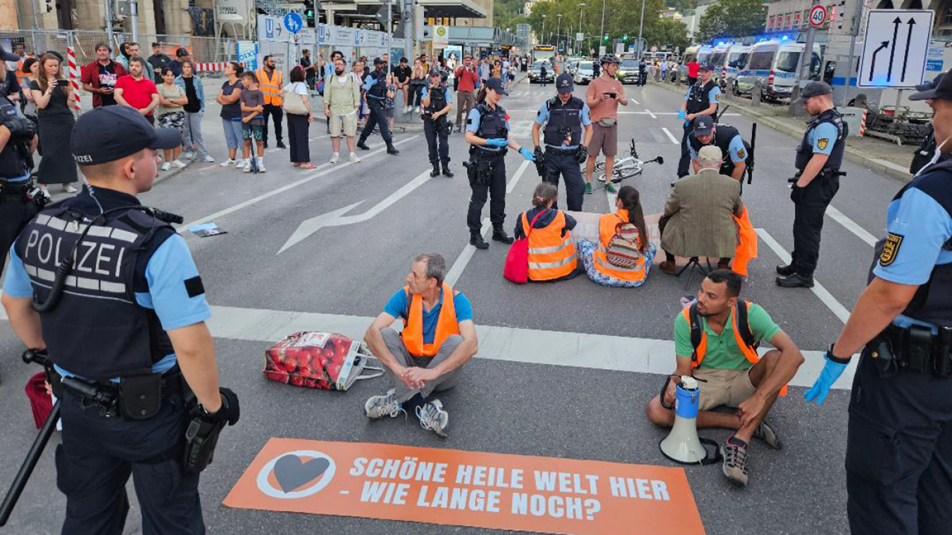 Aktivisten und Aktivistinnen der Klimaschutzgruppe "Letzte Generation" blockieren eine Straße in Berlin.