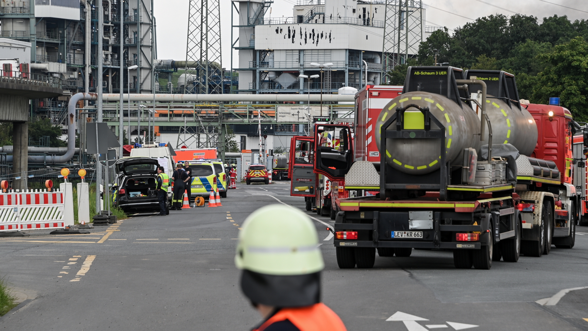 Feuerwehr- und Polizeiwagen und Einsatzkräfte stehen vor dem Chempark-Gelände in Leverkusen, auf dem sich eine schwere Explosion ereignet hat. | EPA