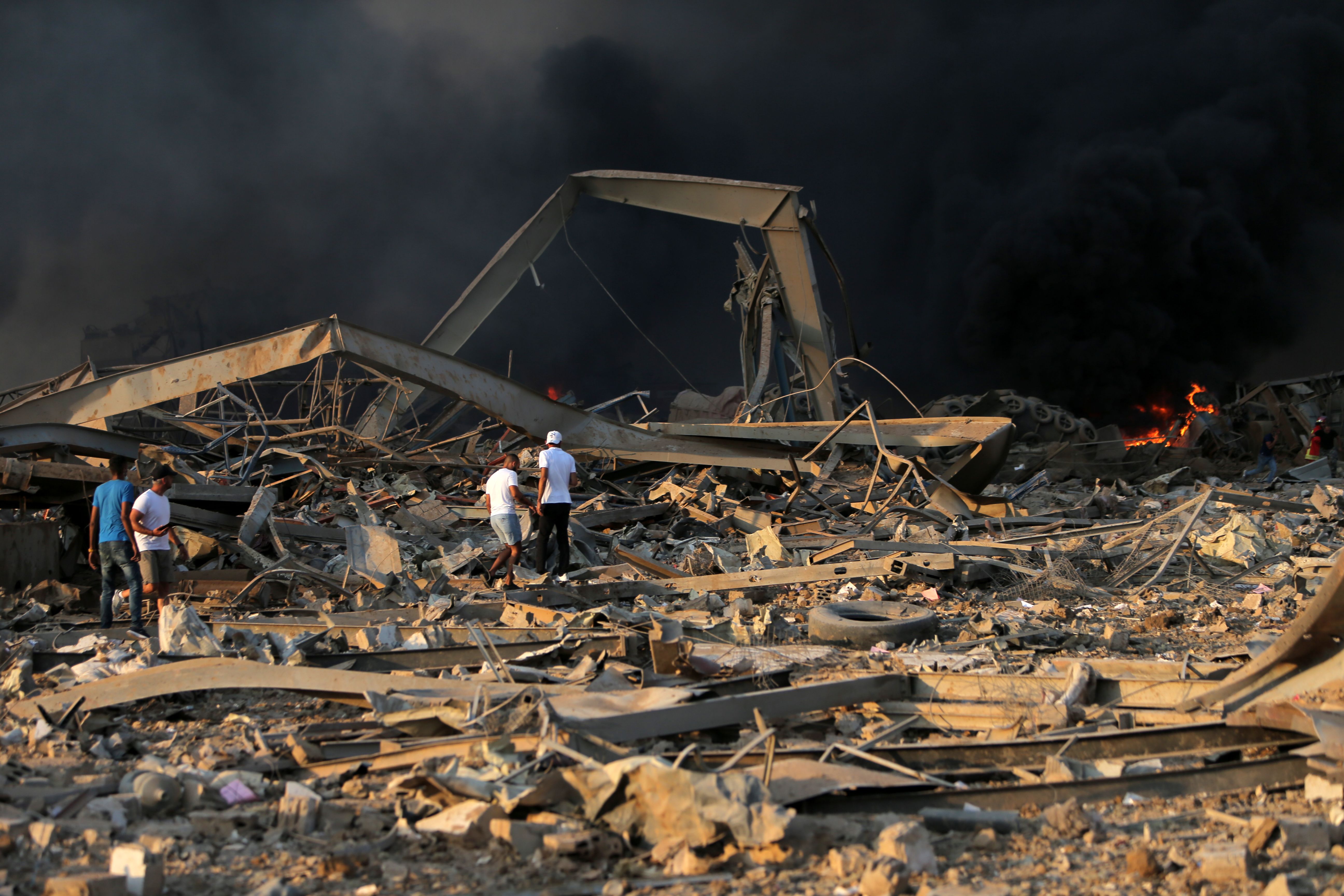 Menschen durchsuchen Trümmer nach einer schweren Explosion in Beirut.  | AFP