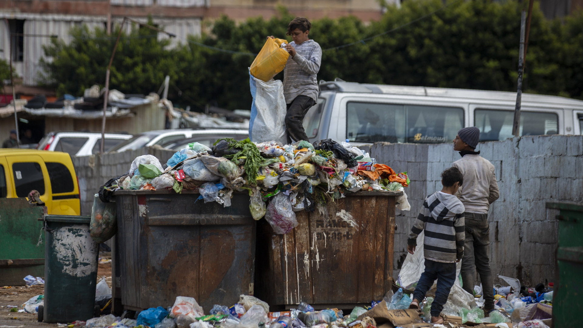 Auf einem Müllcontainer suchen junge Menschen in Beirut nach Verwertbarem. | AP