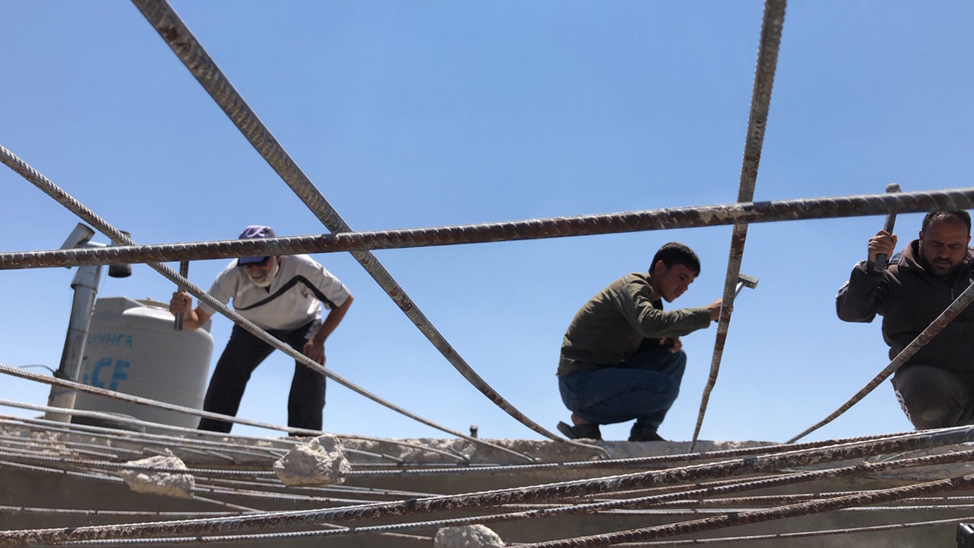Drei Männer reißen ein Haus in einem Flüchtlingscamp im Libanon ab. | Daniel Hechler