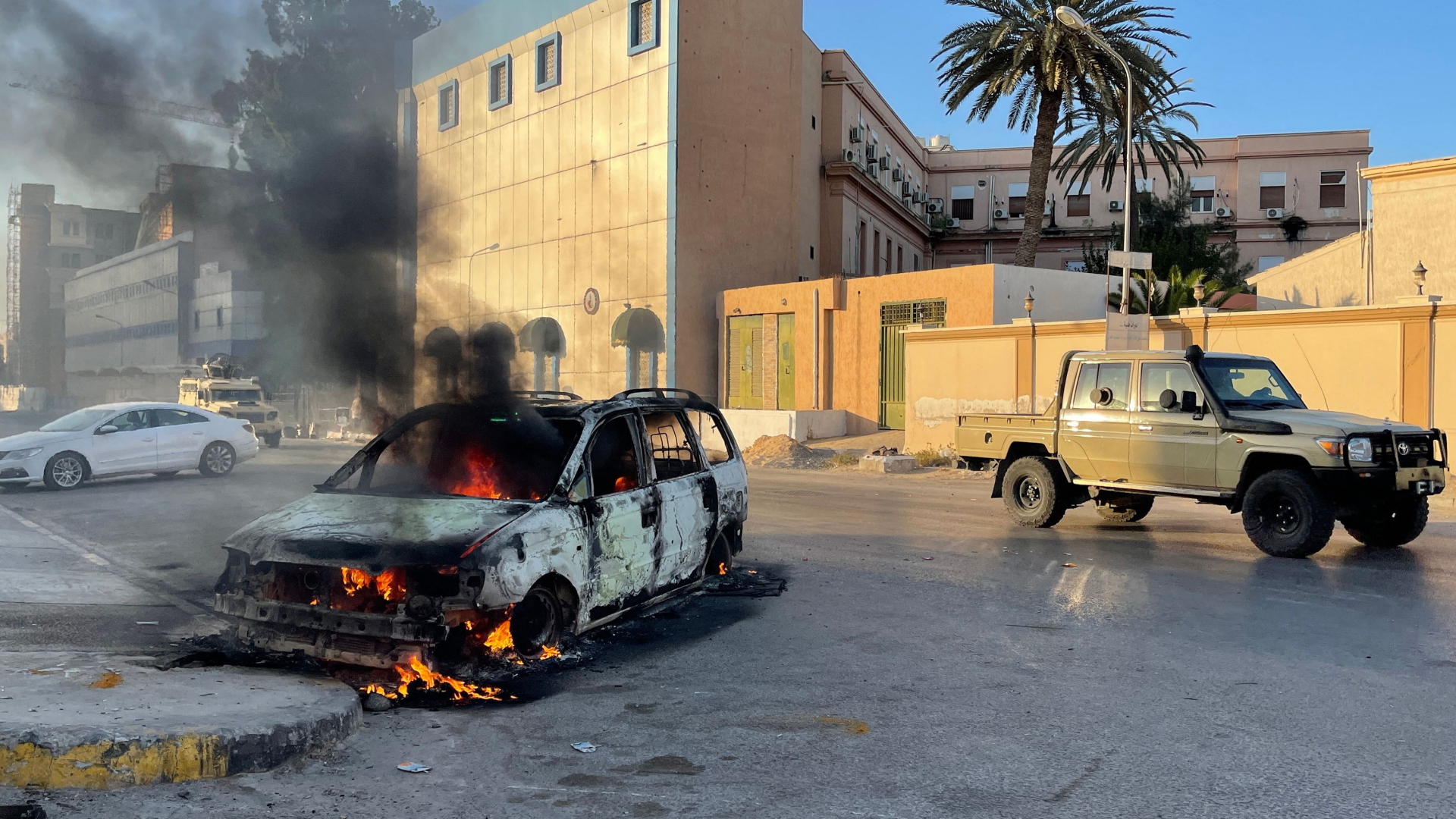 Ein brennendes Auto nach Kämpfen in Tripolis. | AFP
