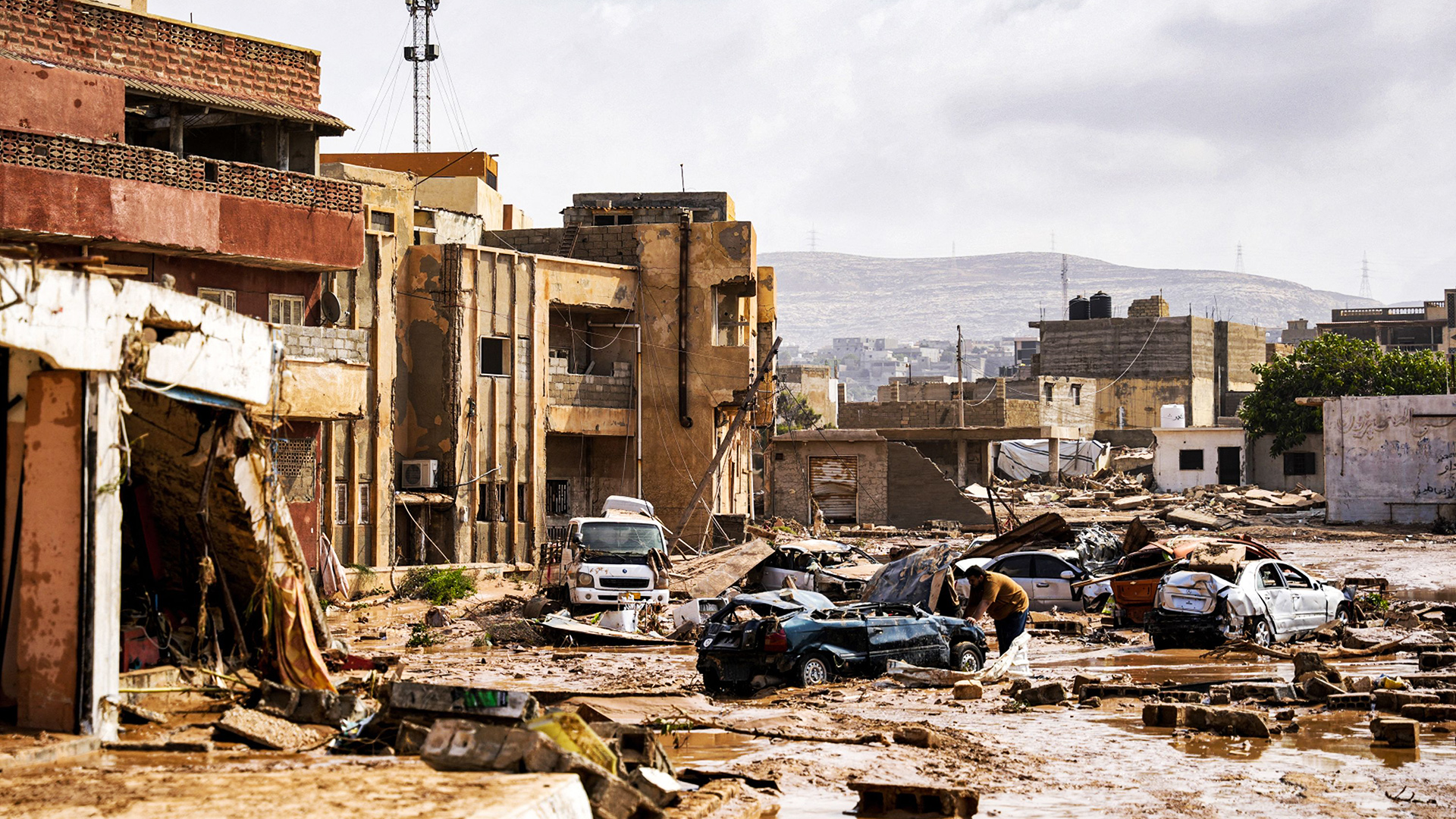 Zerstörte Fahrzeuge und beschädigte Gebäude in der Stadt Derna, Libyen