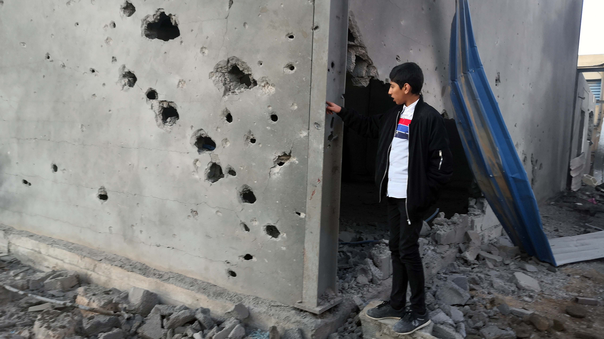 Ein libyscher Junge schaut auf ein zerstörtes Gebäude nach einem Luftangriff im Osten der Hauptstadt. (Archivbild) | dpa