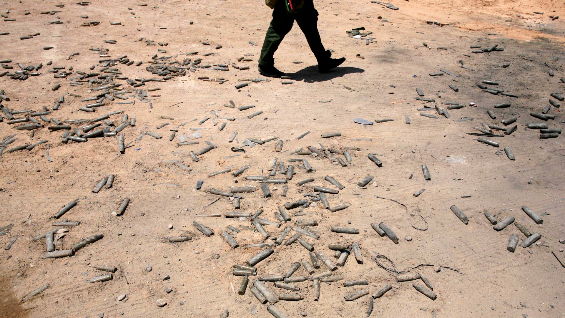 Ein Kämpfer geht in Libyen über mit Patronenhülsen bedecktes Land | EPA