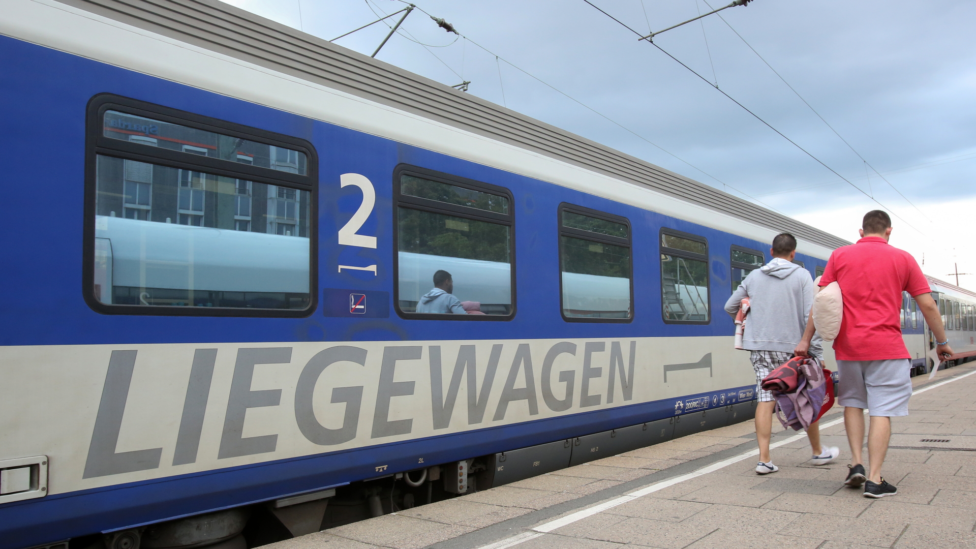 Reisende gehen zu einem Nachtzug (EuroNight) der ÖBB (Österreichische Bundesbahnen), der zur Abfahrt nach Wien im Bahnhof Altona bereit steht.  | dpa
