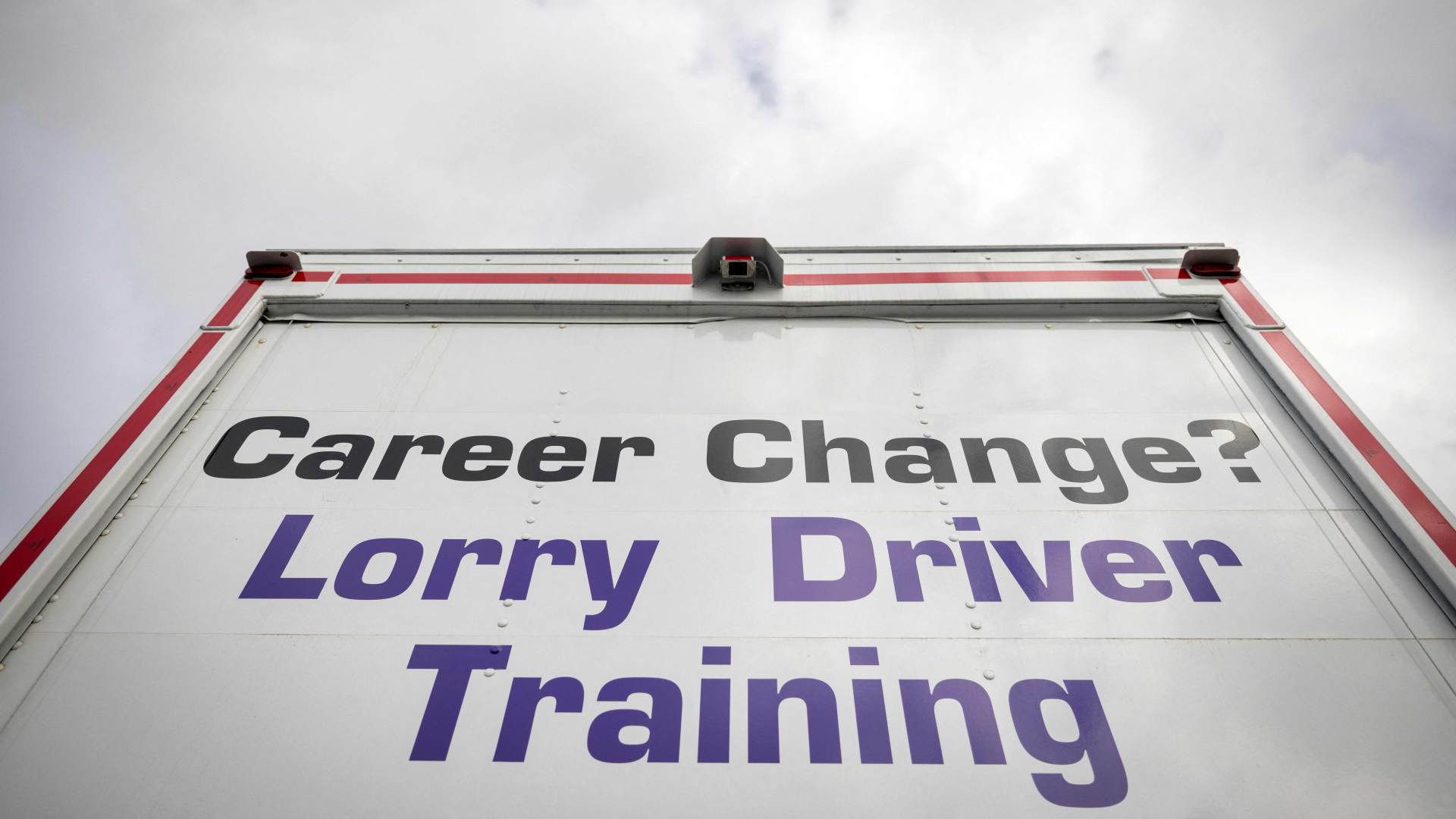 Ein Schild wirbt für eine Karriere als Lkw-Fahrer in Großbritannien. | AFP