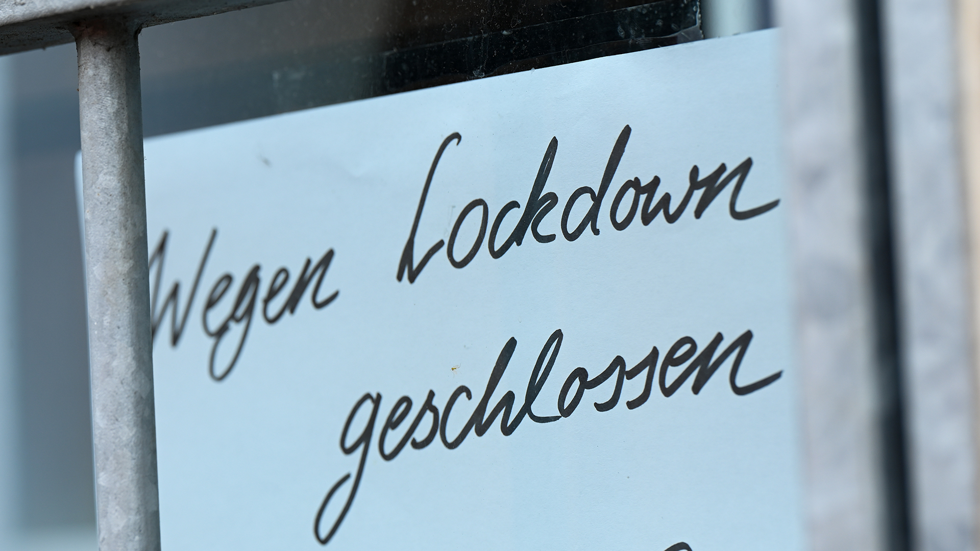 Ein Zettel mit der Aufschrift "Wegen Corona geschlossen" hängt am Schaufenster eines Geschäfts | dpa
