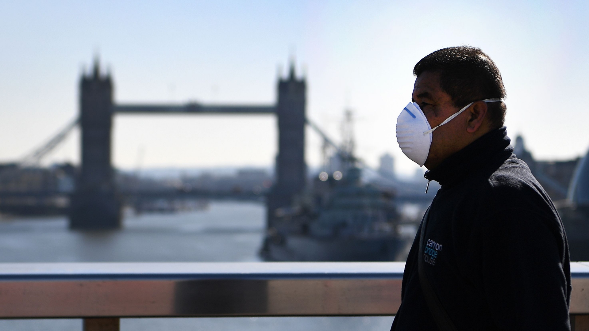 Ein Mann mit einer Schutzmaske in London mit Blick auf die Tower Bridge | ANDY RAIN/EPA-EFE/Shutterstock