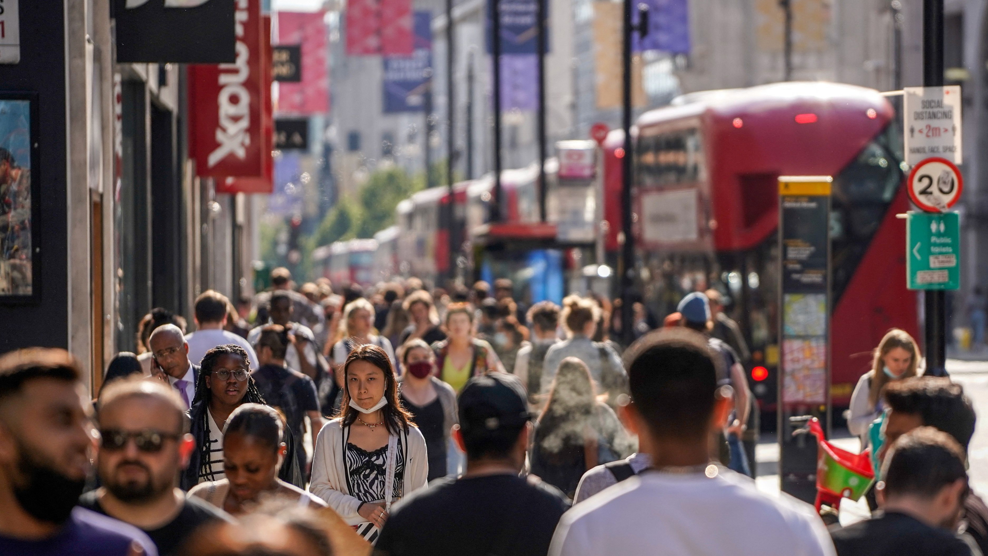 Passanten gehen in London eine Straße entlang. | AFP