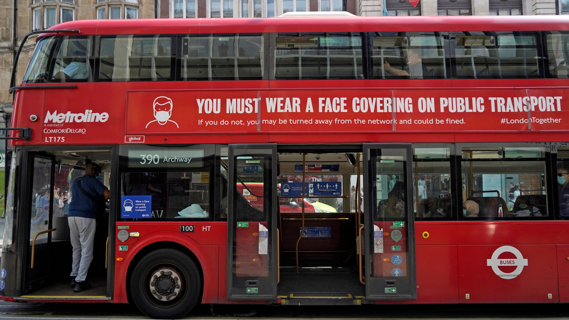 Auf einem der typischen Londoner Doppeldeckerbusse wird auf die Maskenpflicht hingewiesen.