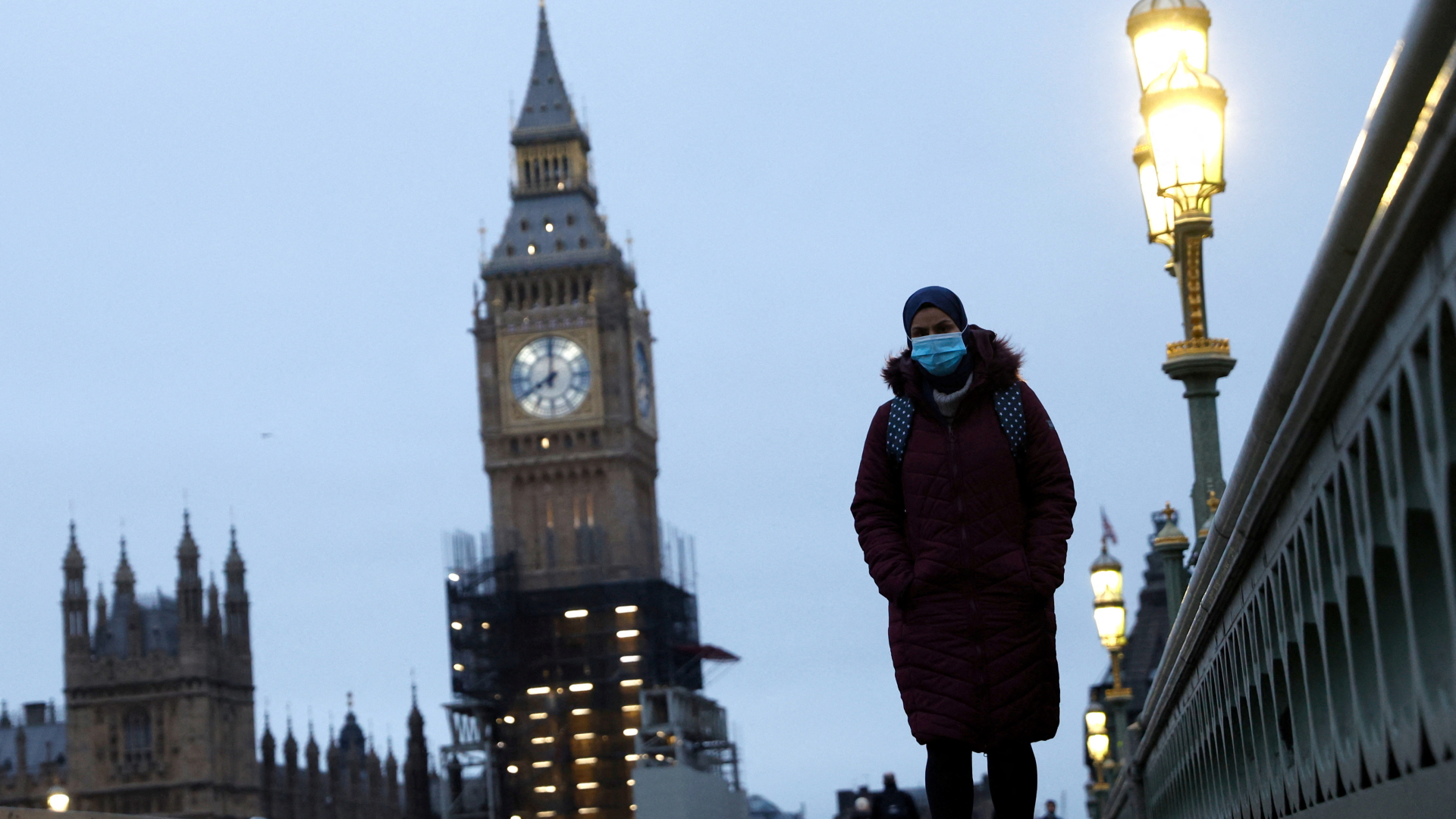 Eine Frau mit Mund-Nasen-Schutz geht über die Westminster Bridge in London | REUTERS