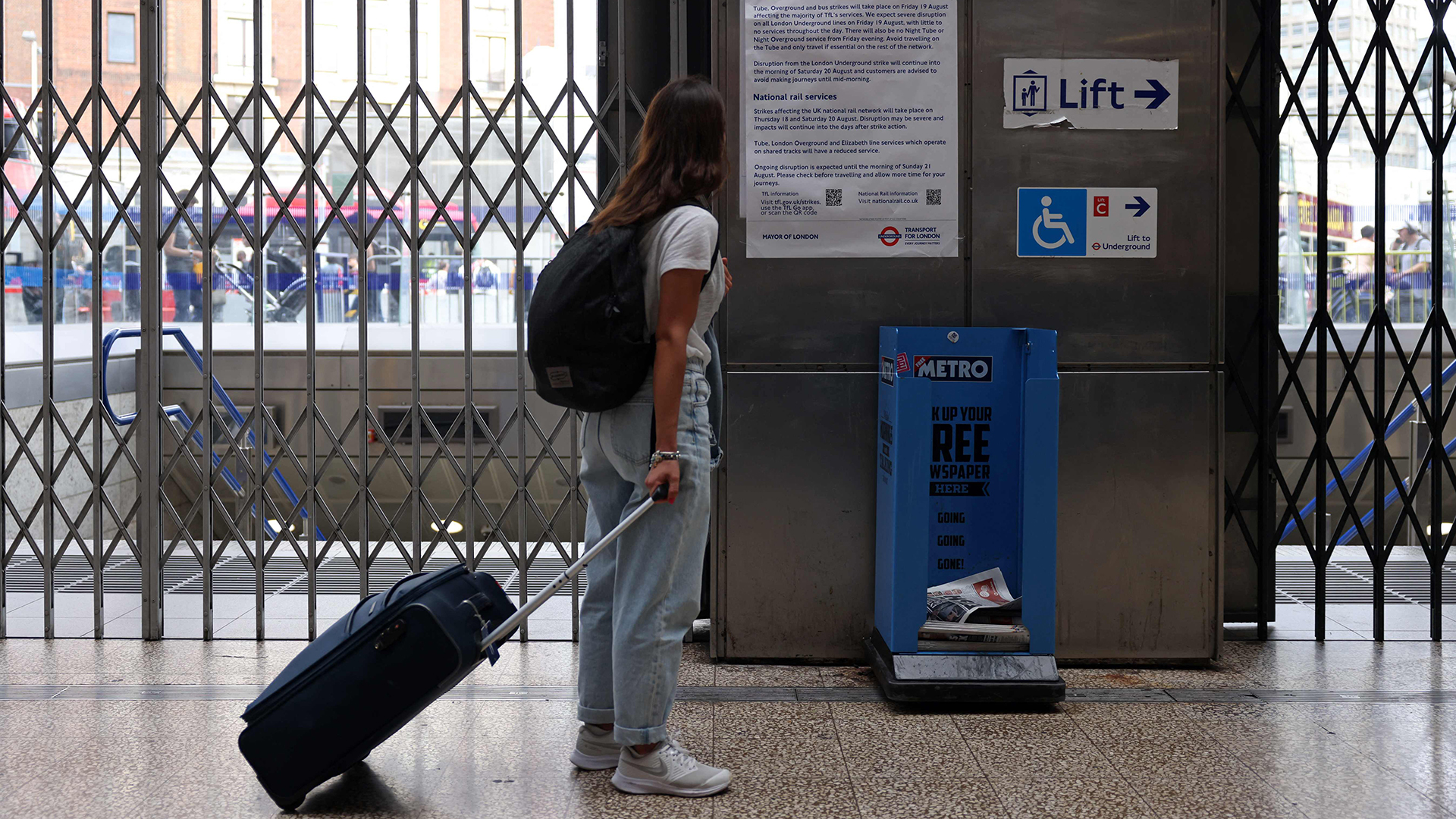 Ein Fahrgast studiert ein Informationsblatt, das vor der Victoria Underground Station in London hängt. | AFP