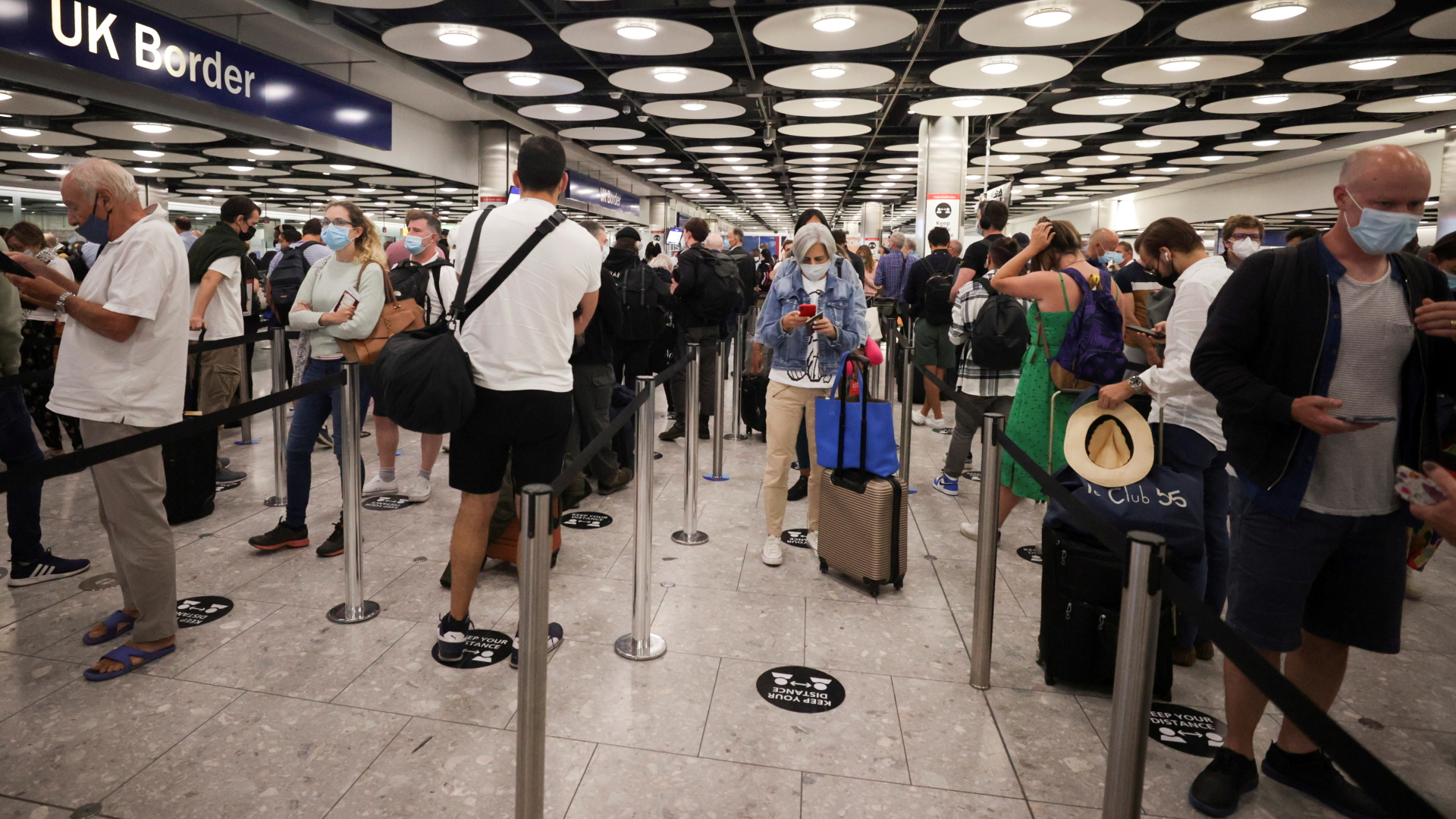 Passagiere stehen am Flughafen Heathrow in der Schlage.