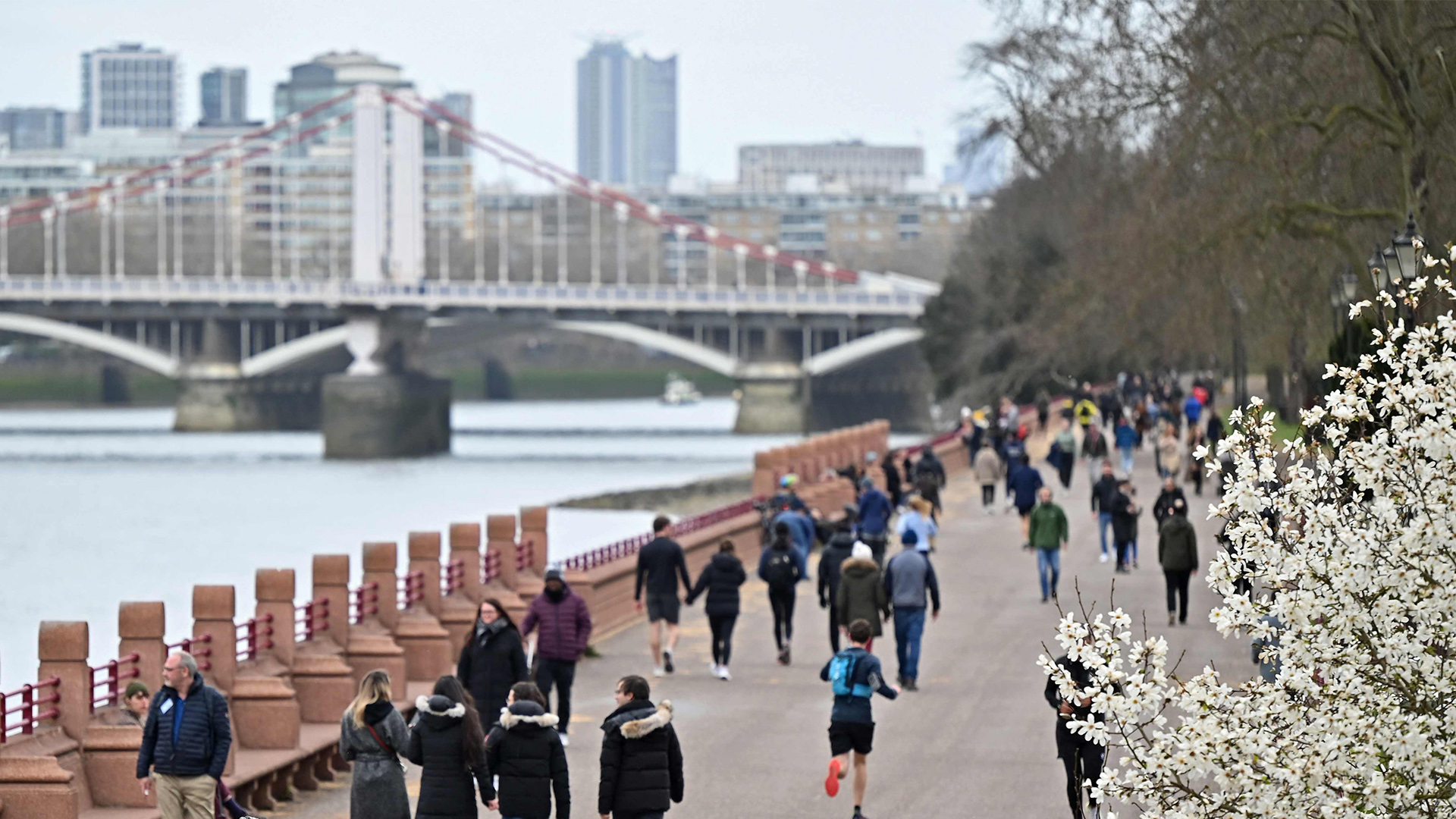 Menschen gehen an der Themse in London spazieren.