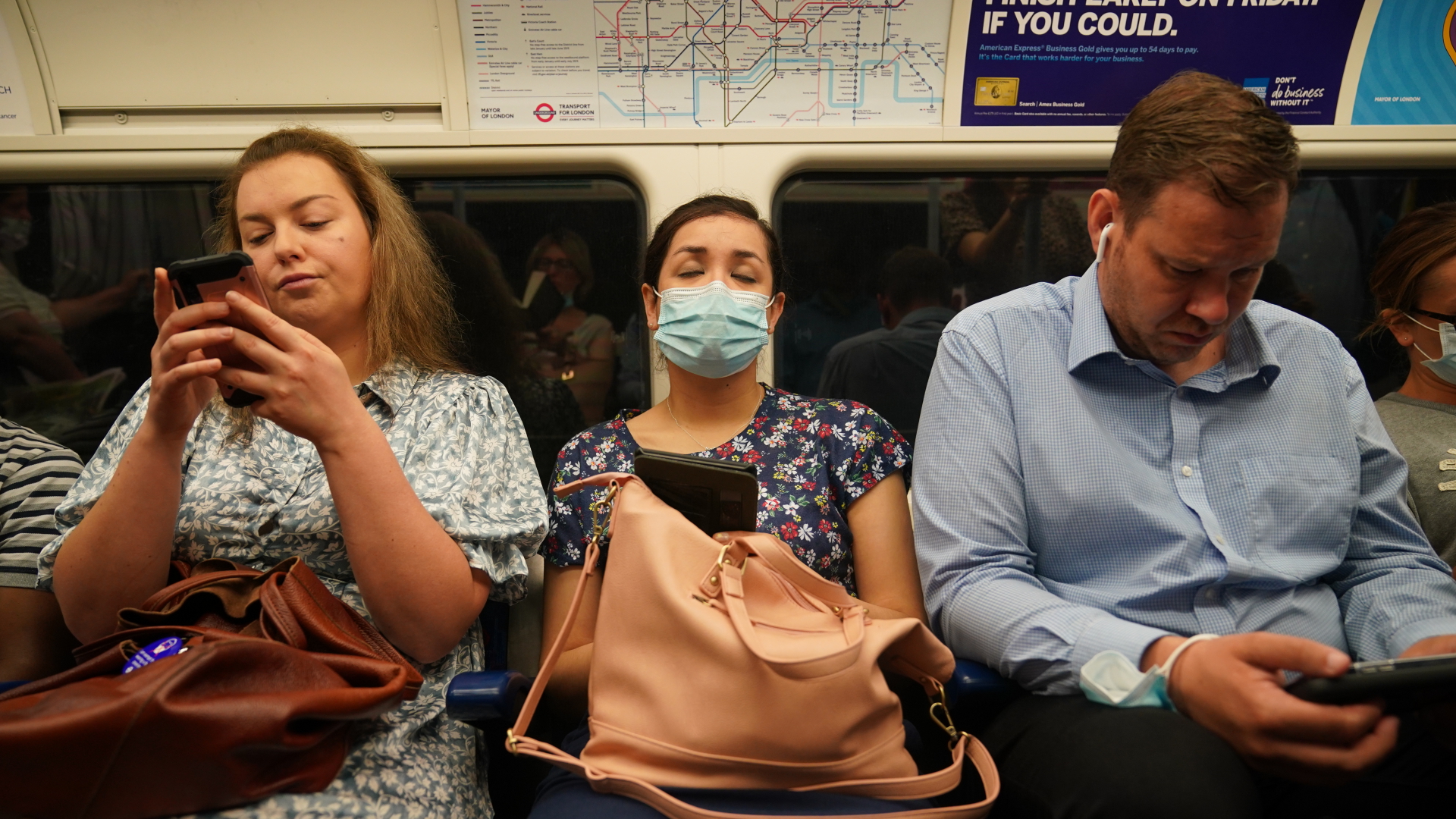 Pendler, einige noch mit Mund-Nasen-Schutz, in einem U-Bahn-Zug der Londoner Jubilee Line nach Westminster | dpa