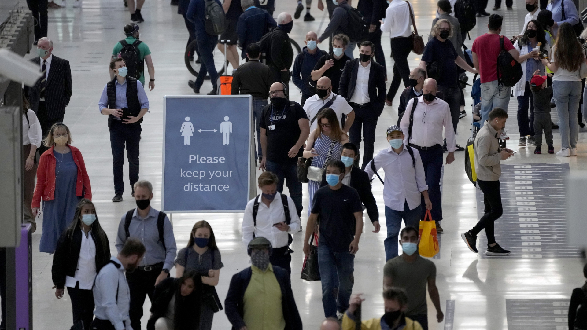 Menschen mit Atemschutzmasken in der Waterloo Station in London. | AP