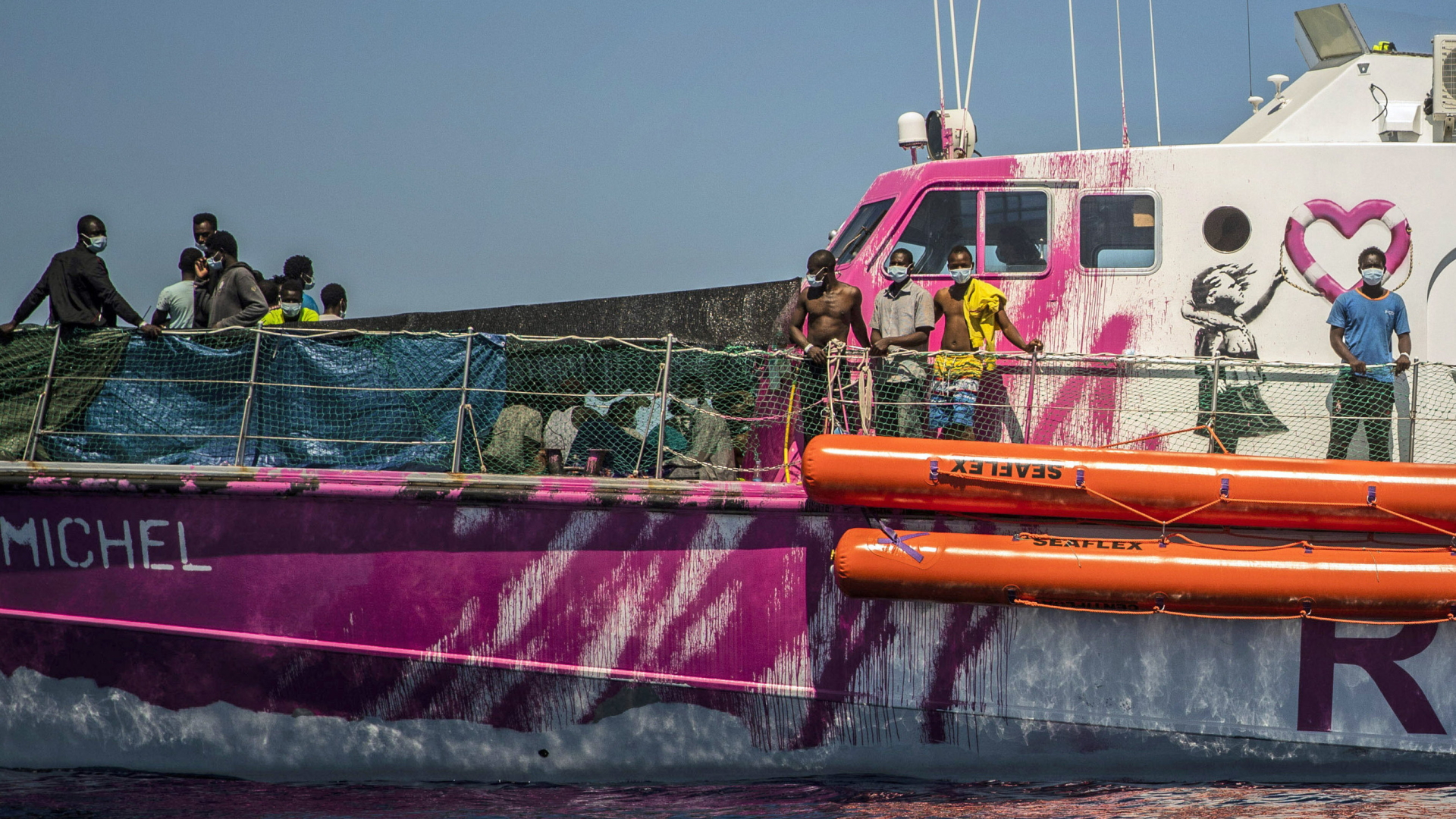 Menschen stehen auf dem Deck des Rettungsschiffs "Louise Michel" | AP
