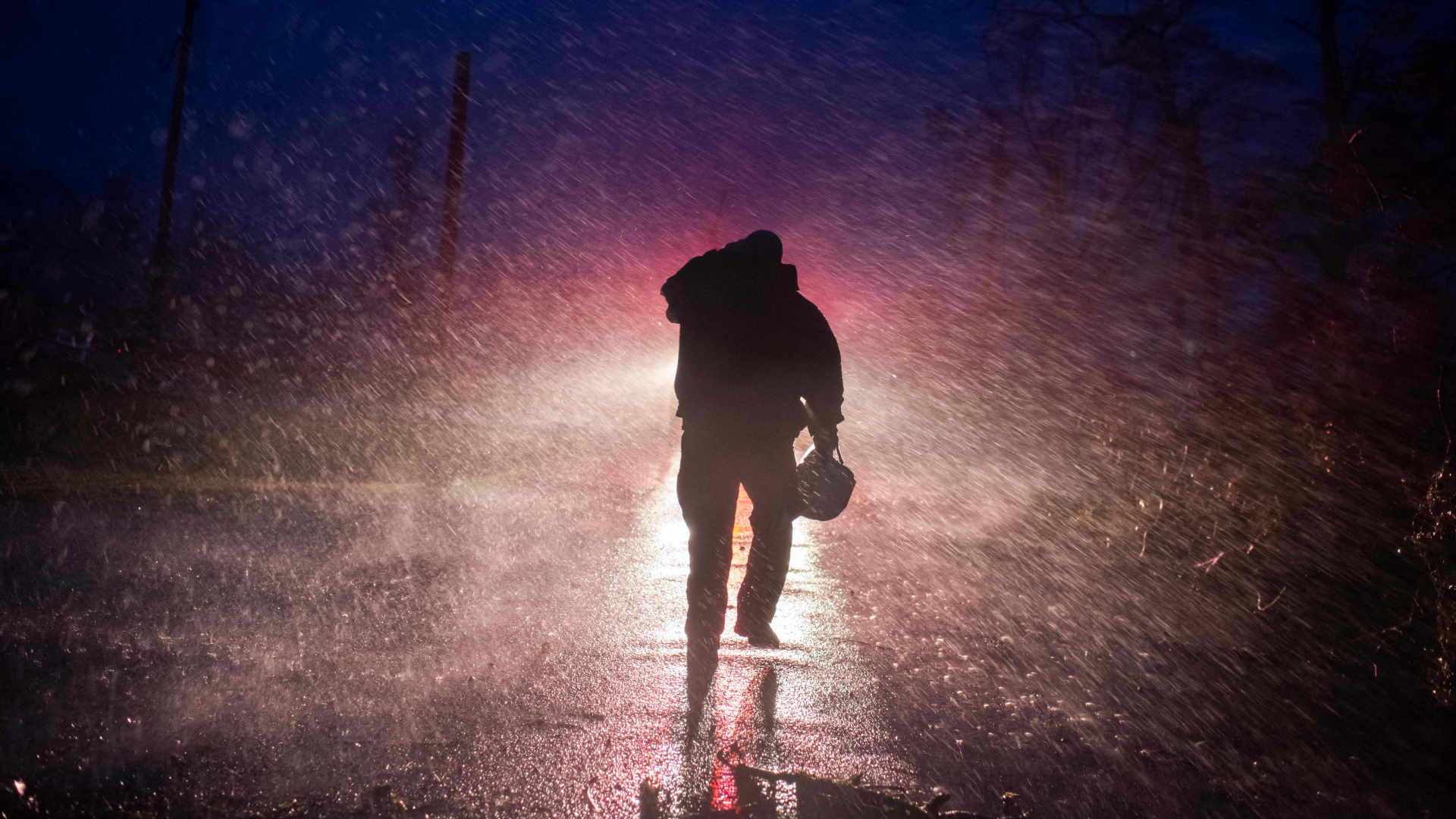 Ein Feuerwehrmann kämpft sich in Bourg, Louisiana, durch den Regen. | AFP