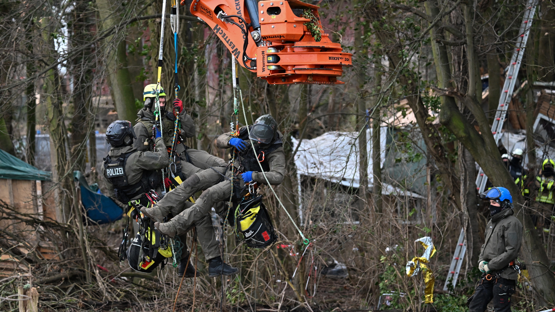Erkelenz: Polizisten in Kletterausrüstung lassen sich von einer Baumschere anheben, um Klimaaktivisten aus den Bäumen zu holen | dpa