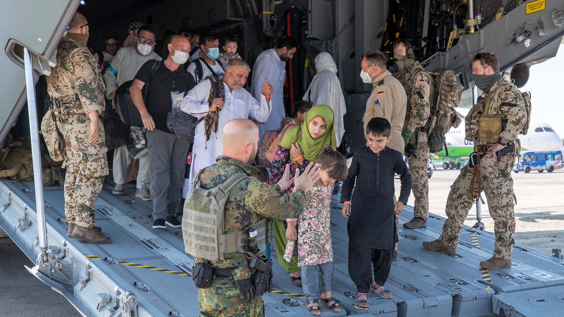 Aus Afghanistan ausgeflogene Menschen verlassen eine Bundeswehrmaschine | dpa