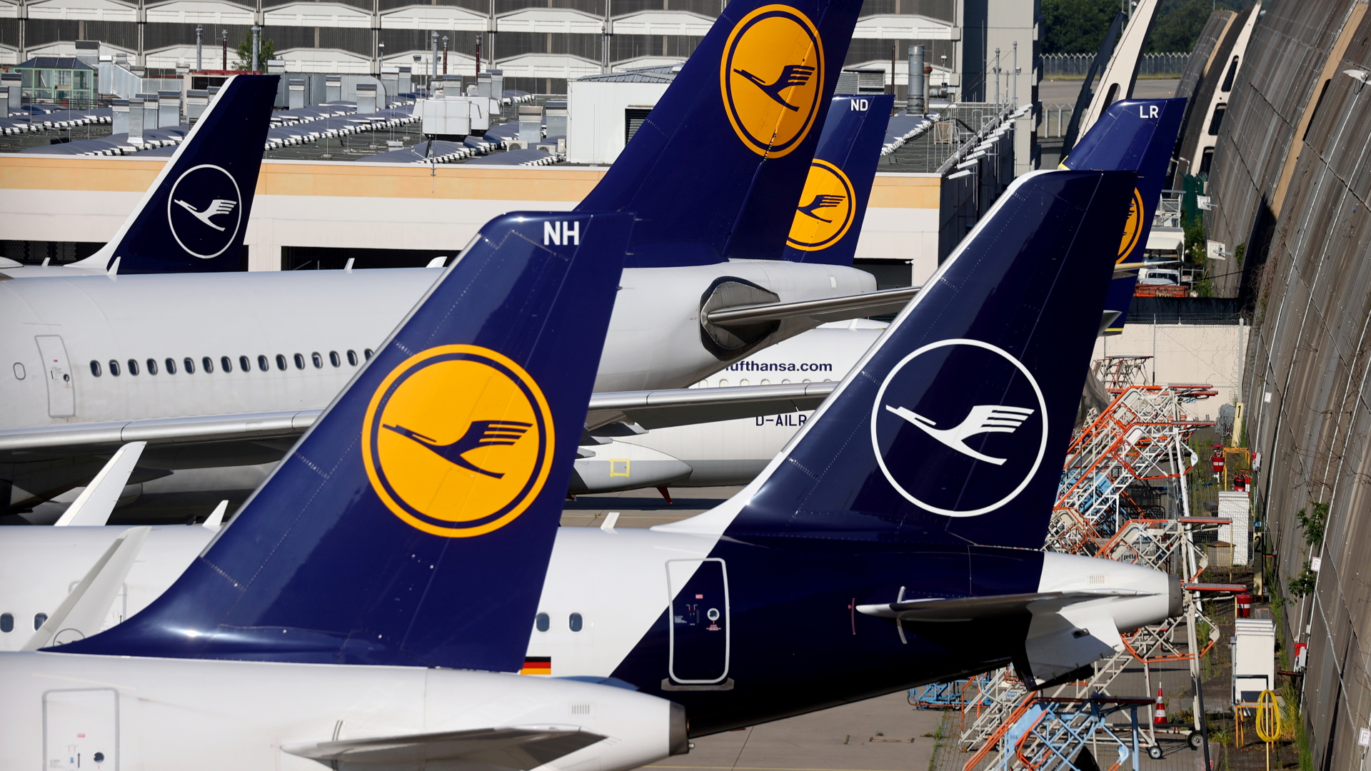 Logo der Lufthansa am Leitwerk mehrerer parkender Flugzeuge | REUTERS