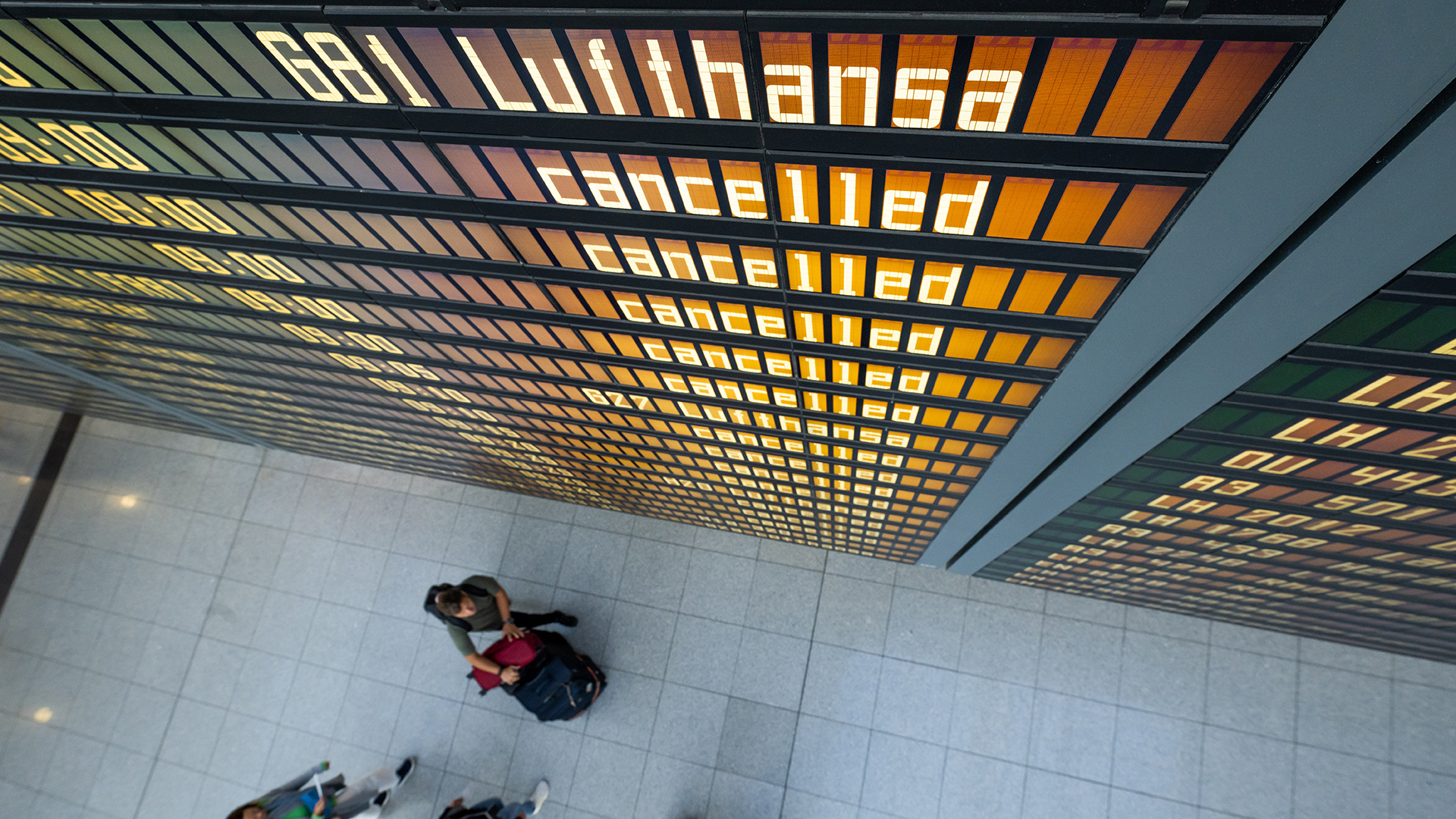 Die Worte "Lufthansa" und "cancelled" sind  an einer Anzeigetafel am Flughafen zu lesen.  | dpa