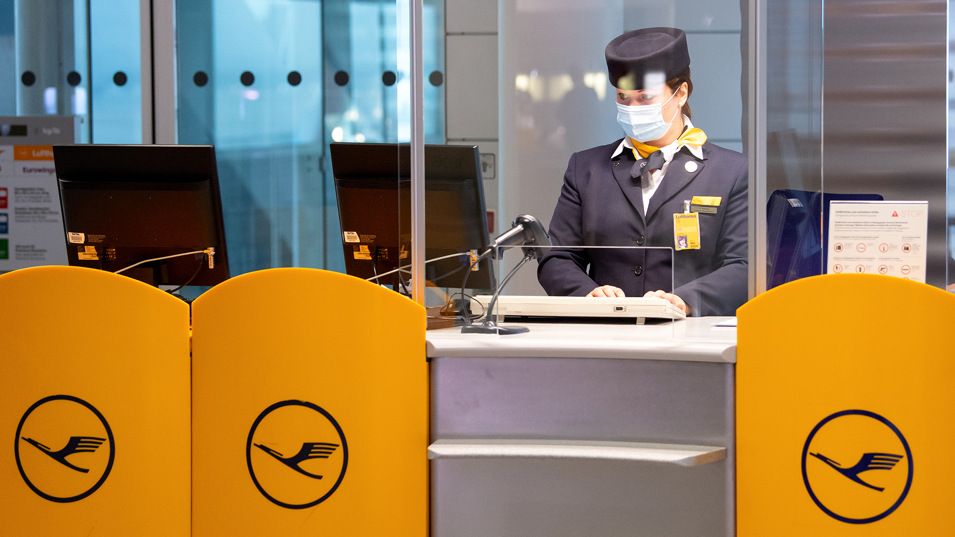 Eine Mitarbeiterin von Lufthansa bereitet an einem Gate am Flughafen München das Boarding für einen Flug vor. | picture alliance/dpa