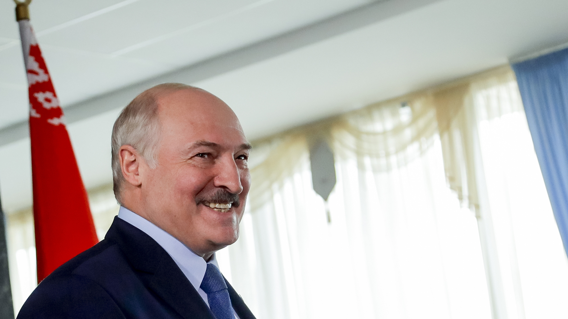 Der belarussische Präsident Alexander Lukaschenko grinst am Wahltag in die Kameras. | dpa