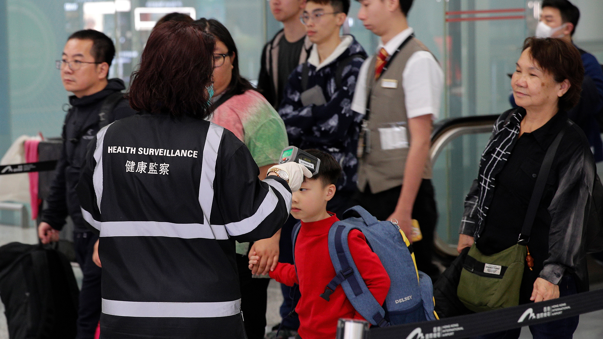 Eine Beamtin der Gesundheitsüberwachung überprüft in der Nähe der Immigrationsschalter die Temperatur von am internationalen Flughafen von Hongkong ankommenden Reisenden.  | dpa