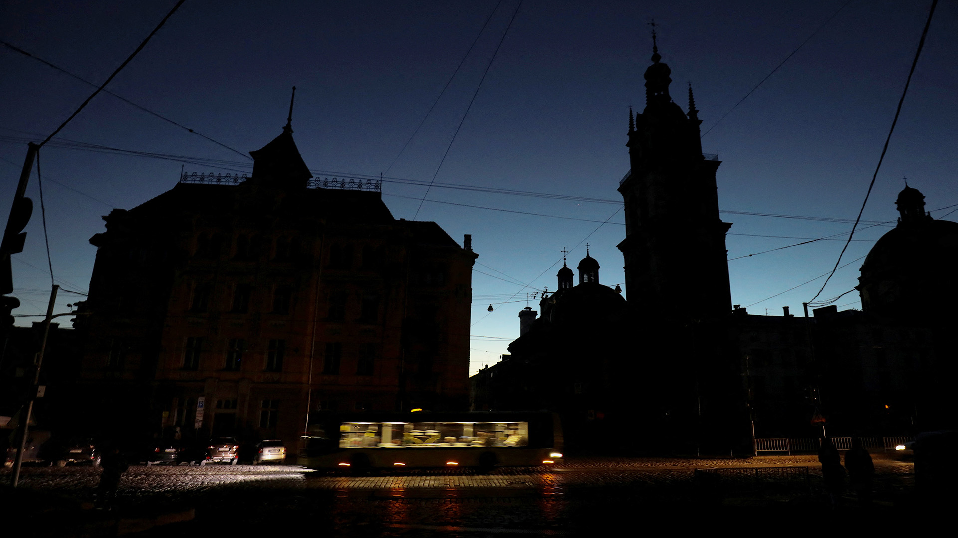 Eine Tram fährt durch eine unbeleuchtete Straße. | REUTERS